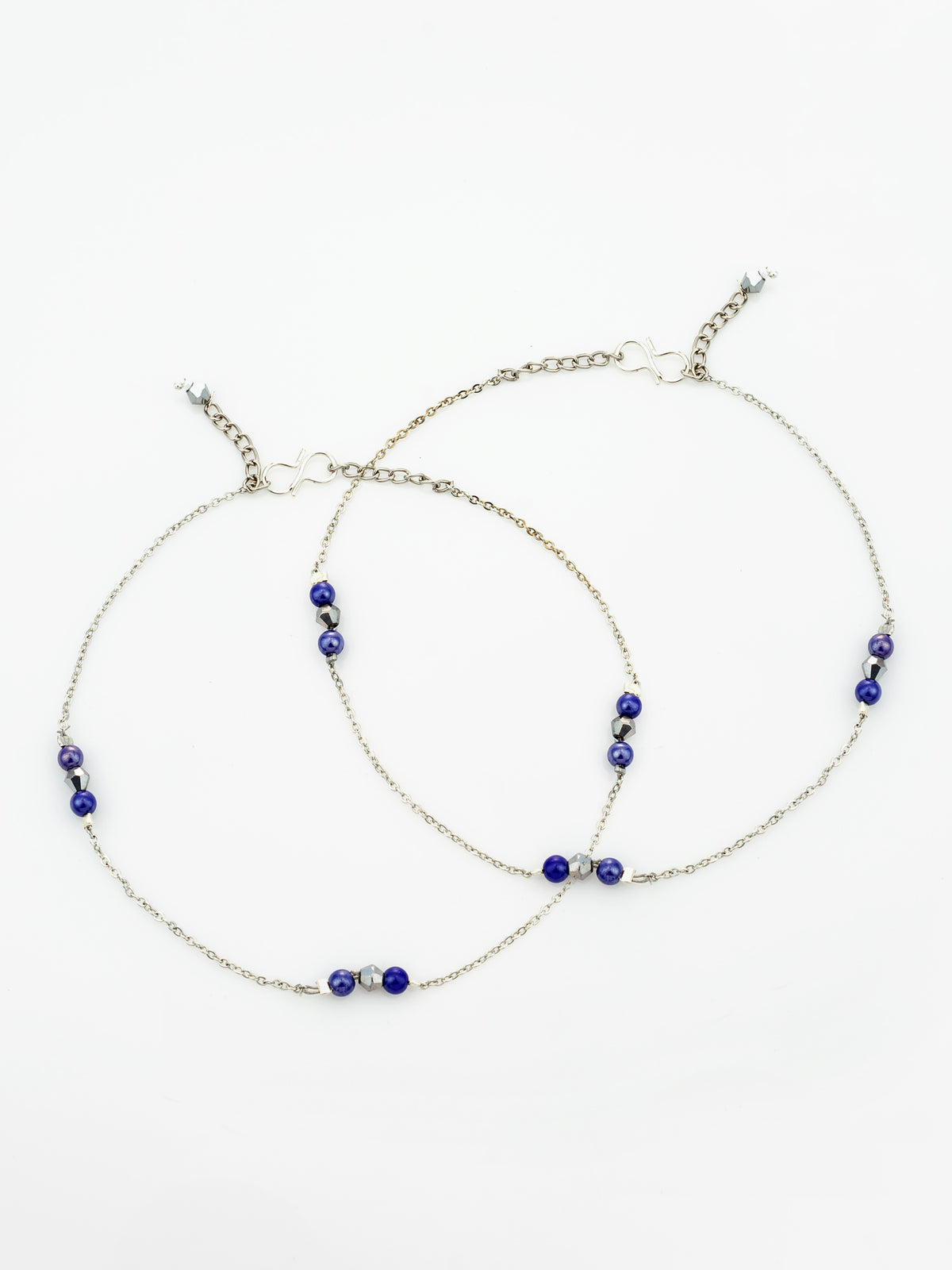 A pair of delicate silver chain anklets with small blue beads and silver spacer beads, displayed on a clean white background.