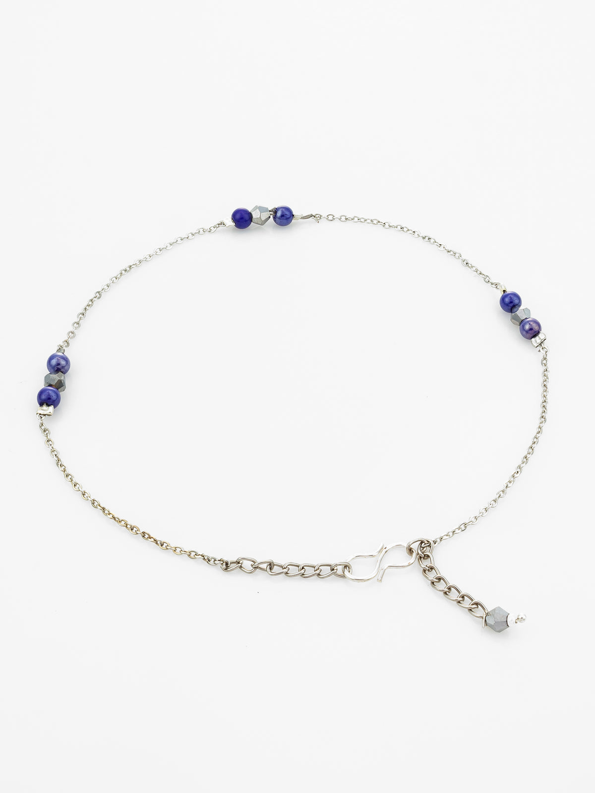 A delicate silver chain anklet featuring small blue and clear faceted beads spaced along the chain, with an adjustable heart-shaped link extender and a small dangling charm, displayed on a clean white background.