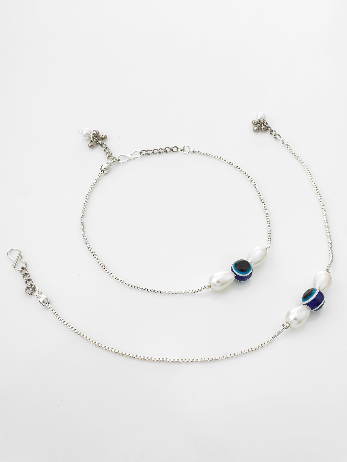 A delicate silver chain anklet featuring white freshwater pearls and blue-and-black evil eye beads, displayed on a clean white background.