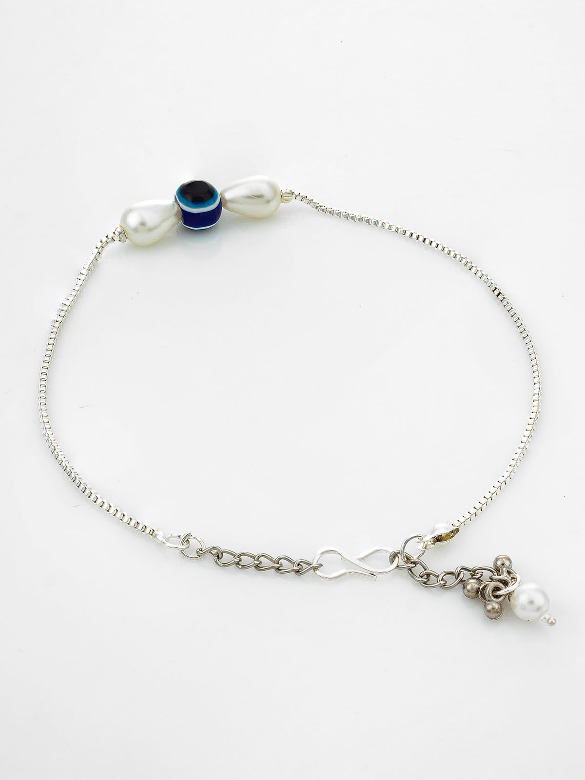 A delicate silver chain anklet featuring a white pearl, a dark blue evil eye bead with a light blue border, and a dangling charm with a small white pearl, displayed on a clean white background.