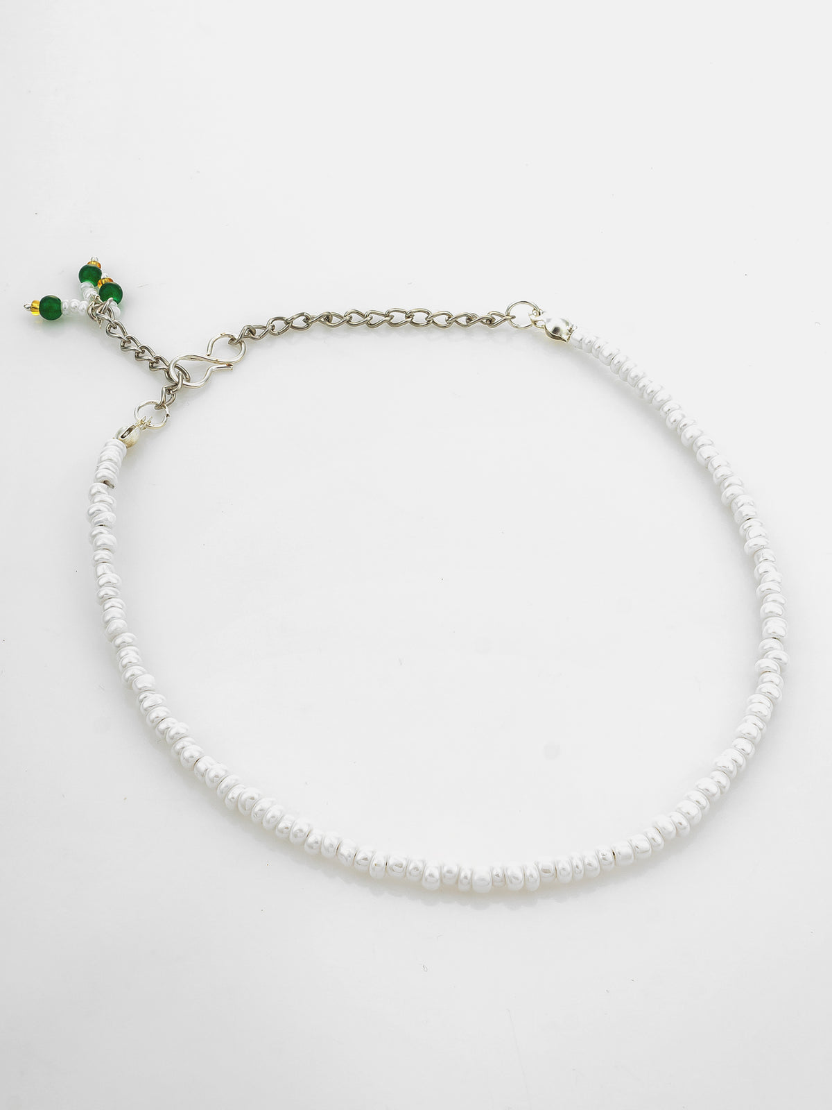 A white beaded necklace with a silver-tone chain extender and small green bead accents, displayed on a clean white background.
