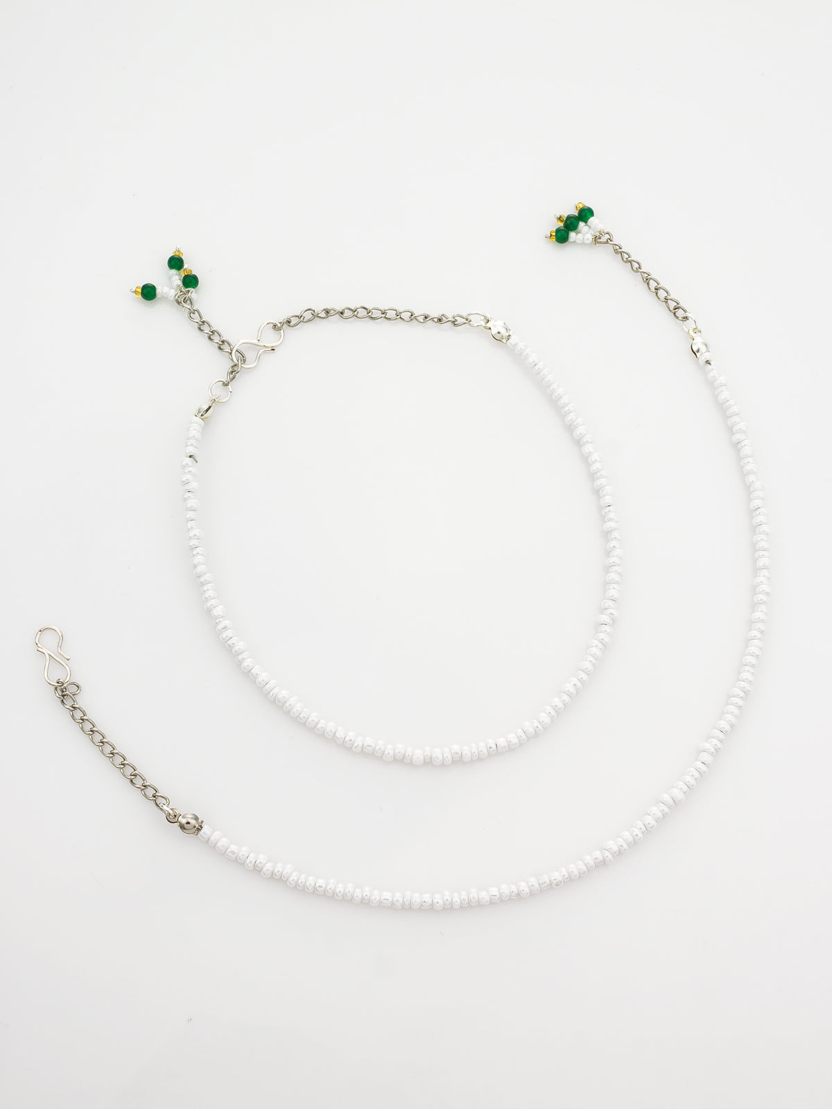 A white beaded ankle chain necklace with silver-tone metal chains and small green bead accents, displayed on a clean white background.