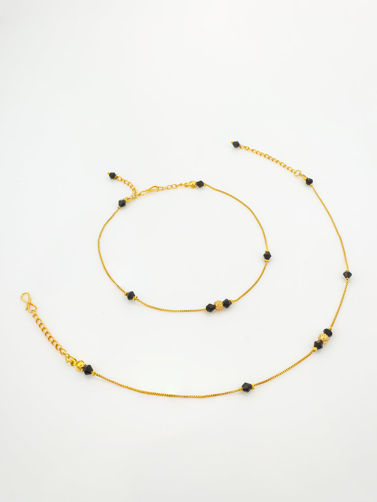 A delicate gold chain anklet with small black faceted beads spaced along the chain, displayed on a clean white background.
