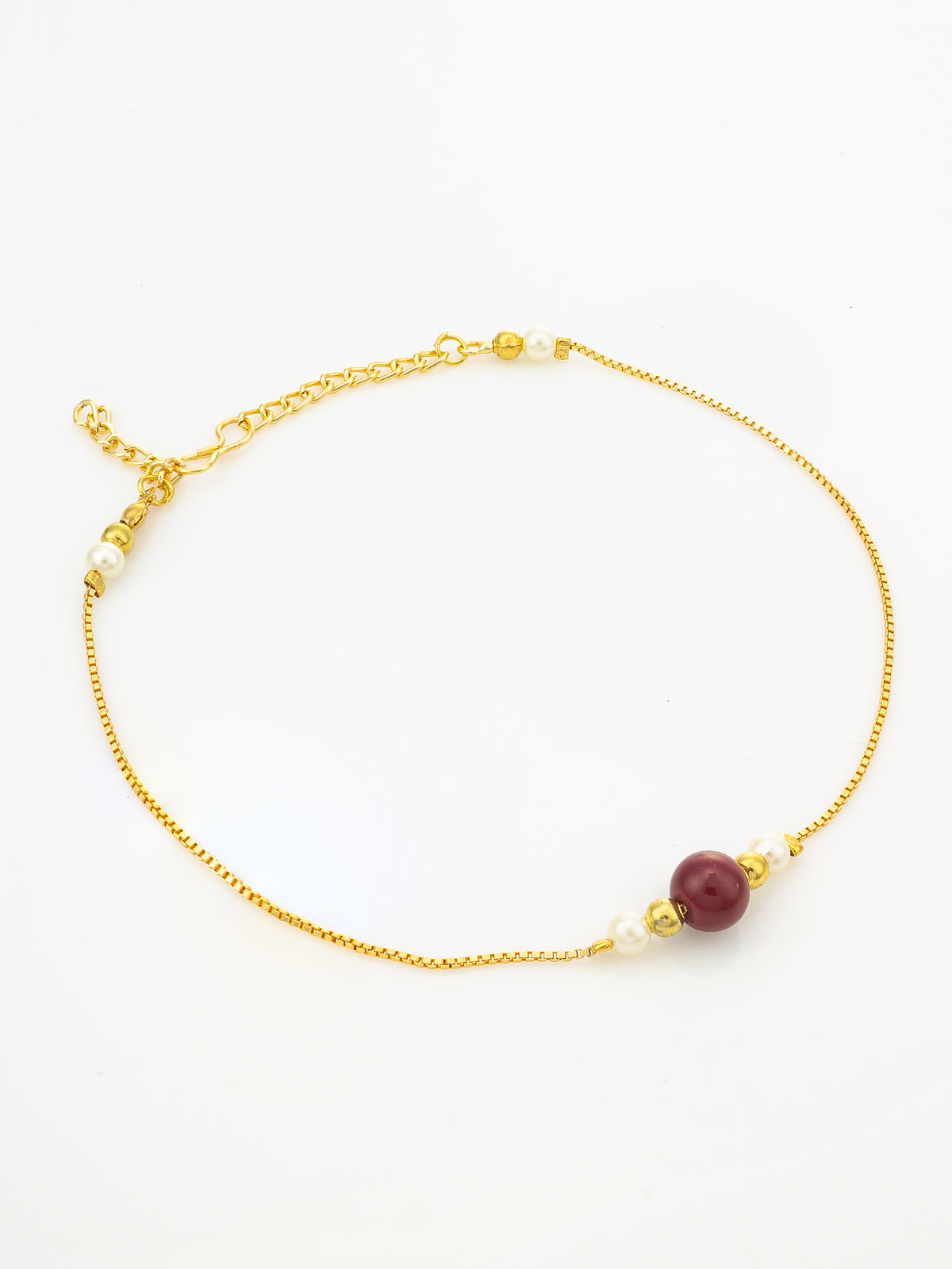 A delicate gold chain anklet featuring a single round dark red bead and small white pearl-like beads, displayed on a clean white background.
