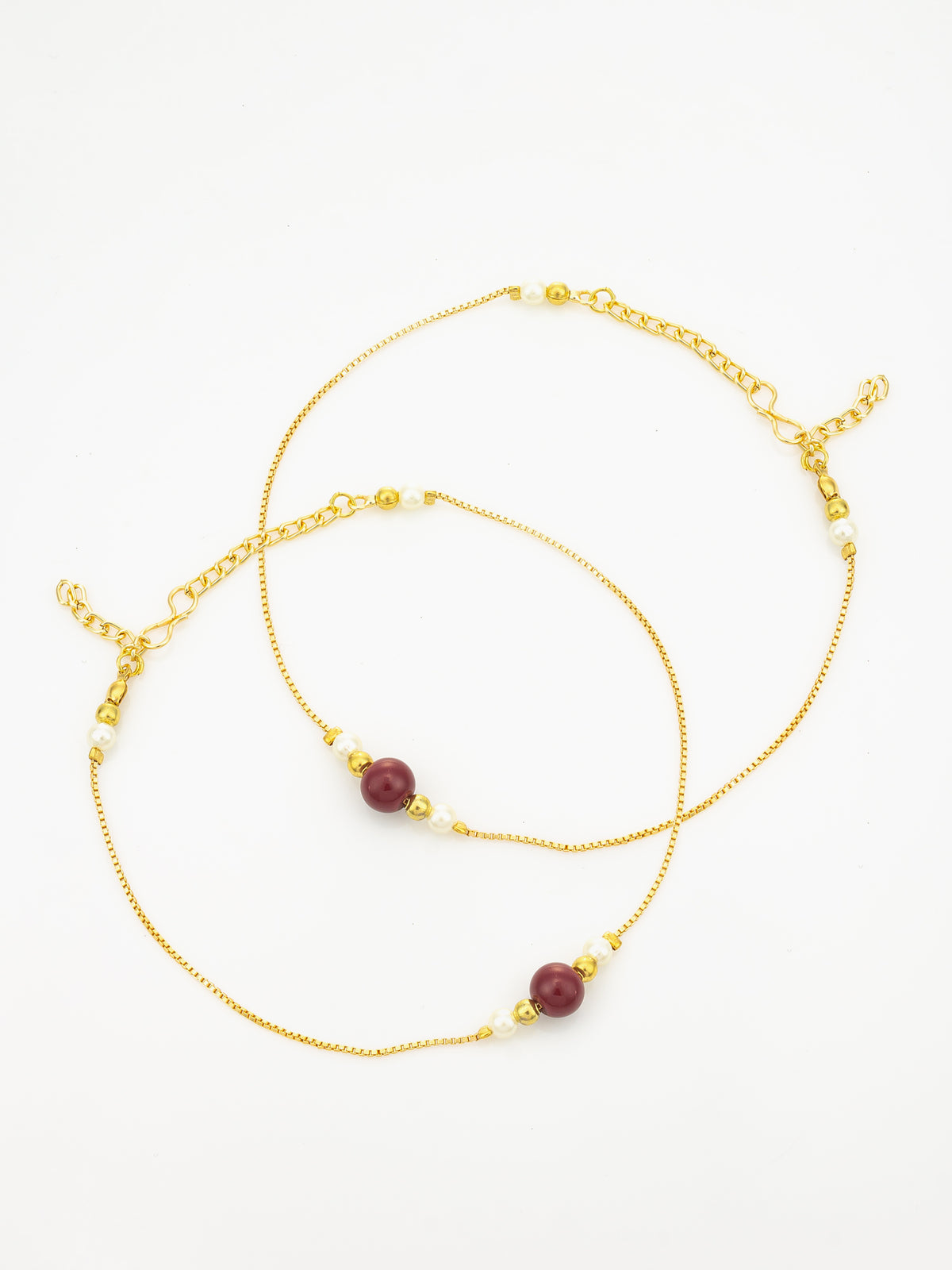 A delicate gold chain anklet featuring two round dark red beads and small white pearl-like beads, displayed on a clean white background.