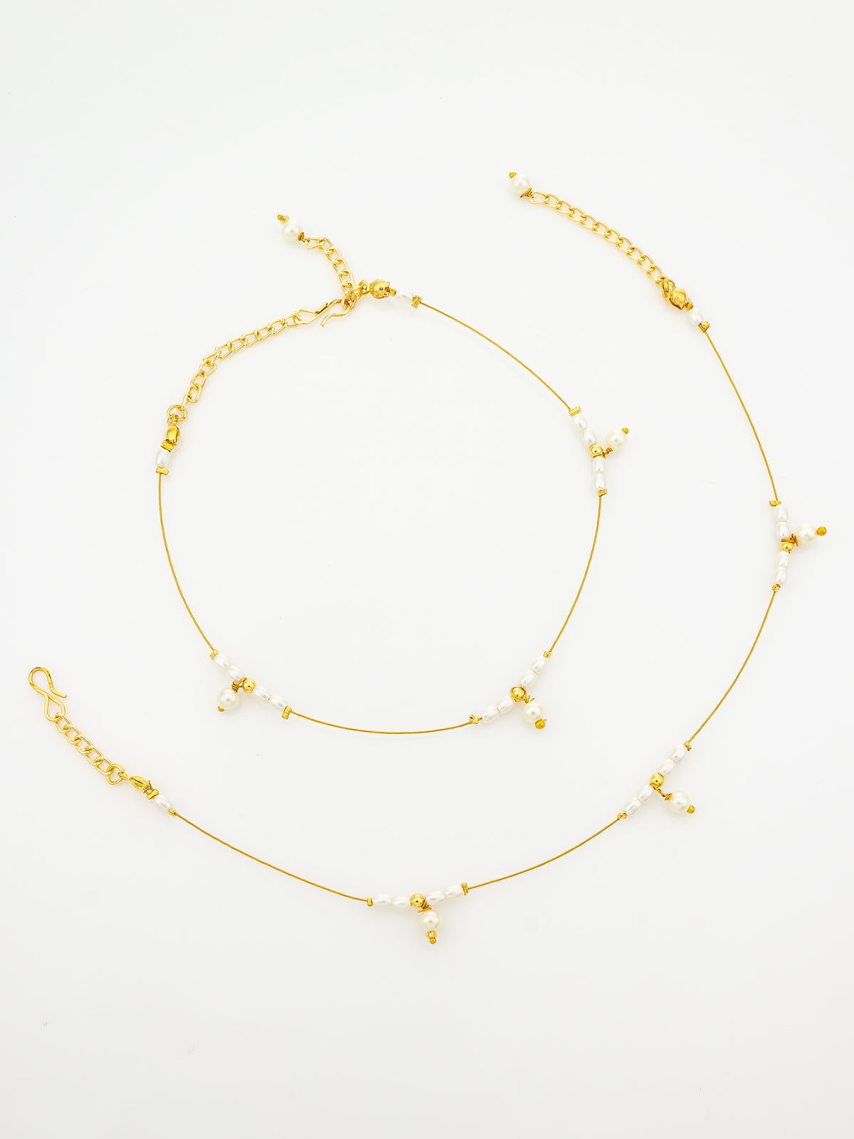 A delicate gold chain anklet with small white pearl-like beads and tiny gold spacer beads, displayed on a clean white background.