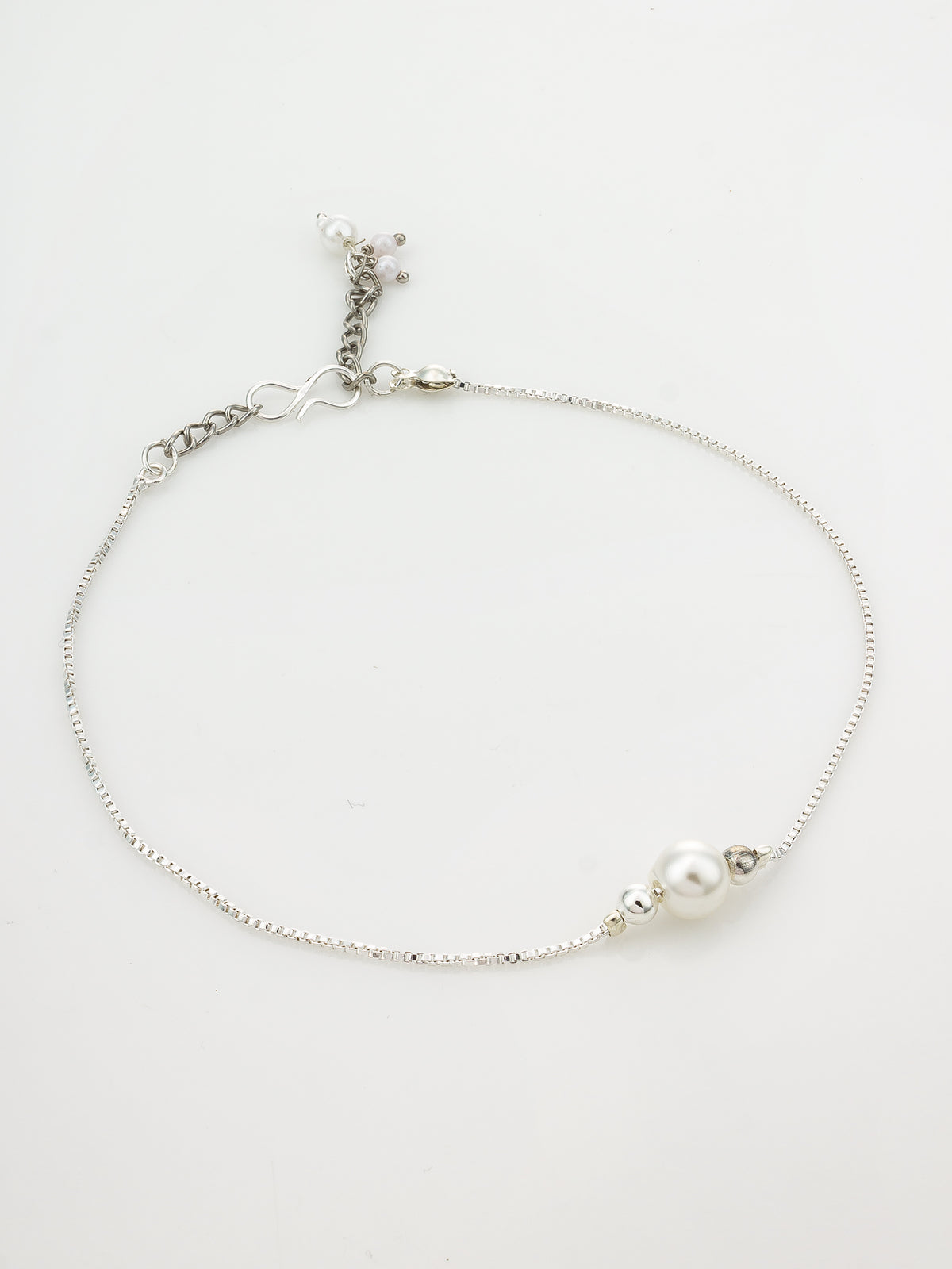 A delicate silver chain anklet featuring a single white pearl bead and a small silver spacer, displayed on a clean white background.
