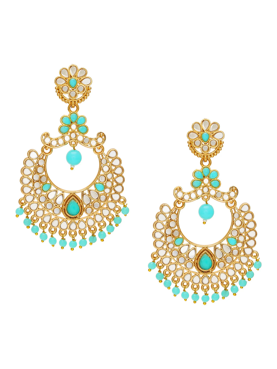 A pair of ornate gold-toned dangle earrings with turquoise blue stones and white inlay, displayed on a carved wooden box with dark green satin fabric in the background.