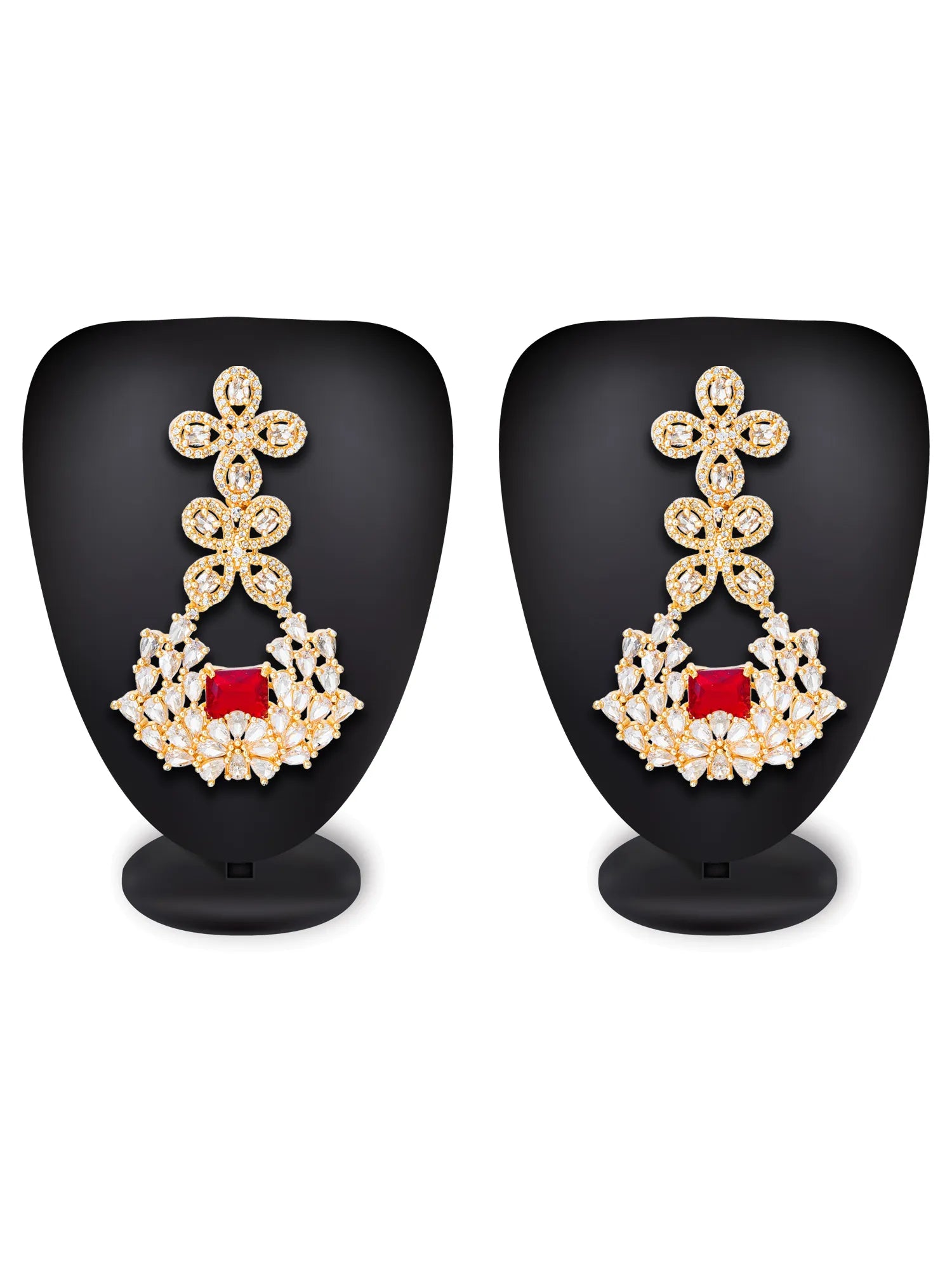 A pair of gold-toned dangle earrings with clear stones and a central red square gemstone, displayed on black mannequin busts against a white background.