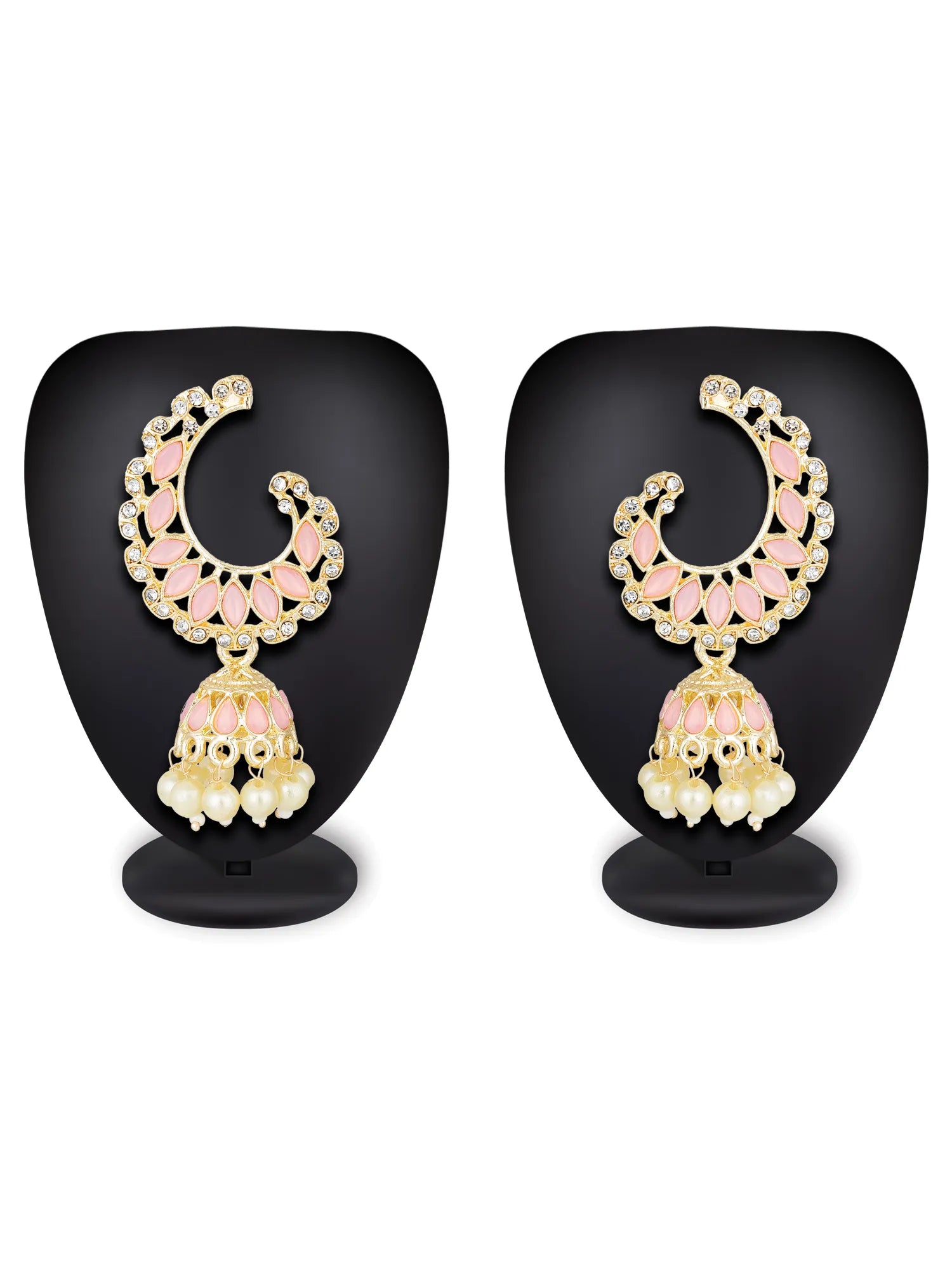 A pair of gold-plated crescent-shaped Jhumka earrings with pink enamel detailing and white bead drops, displayed on black mannequin stands against a white background.