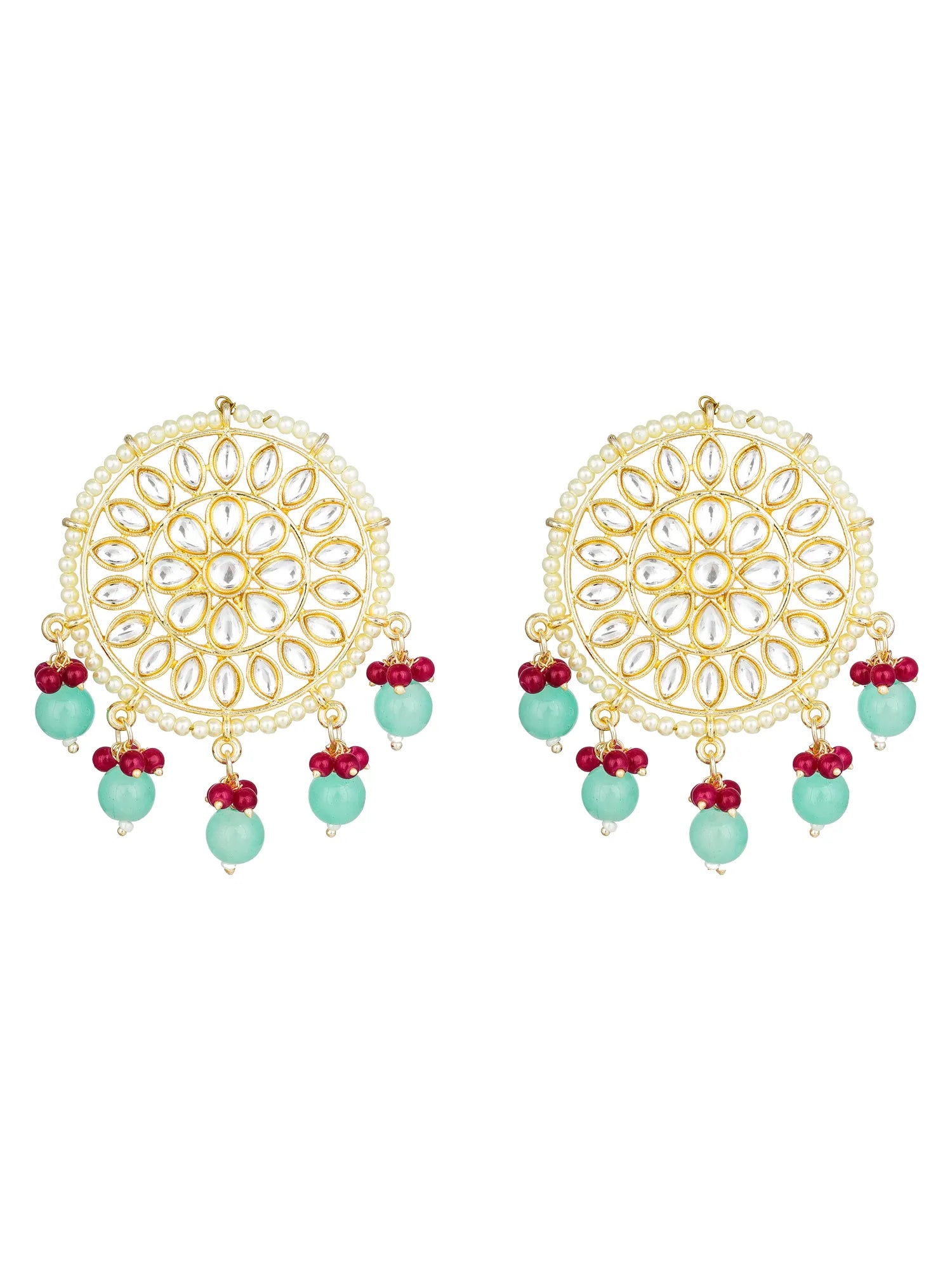 A pair of gold-toned Indian chandelier earrings with intricate filigree detailing, small clear stones, and dangling light green beads accented with red floral elements, shown on a plain white background.