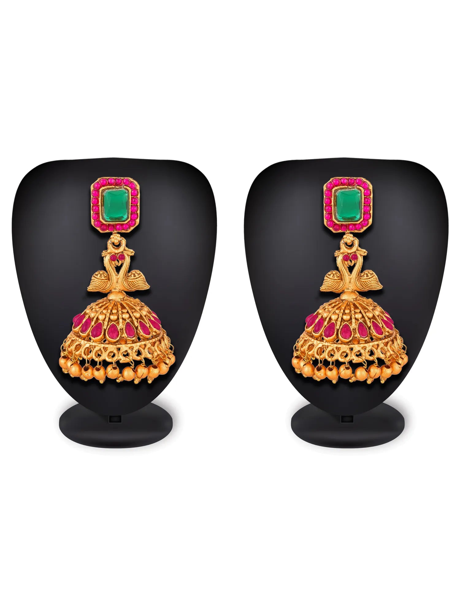 A pair of gold-plated traditional Indian jhumka earrings with green rectangular stones and pink rhinestone borders, displayed on black mannequin stands against a white background.