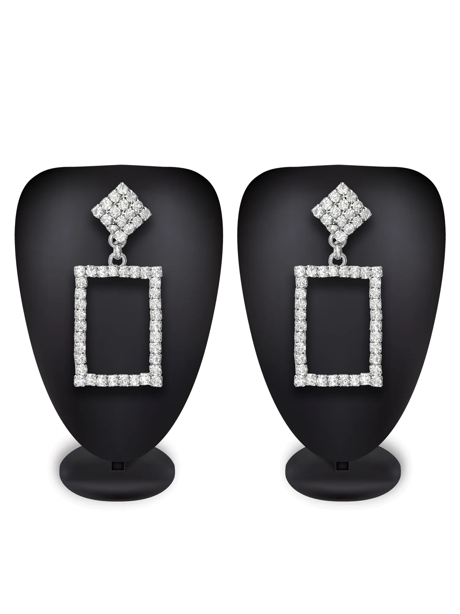 A pair of rectangular drop earrings with diamond-like clear stones set in silver-toned metal, displayed on black mannequin busts against a white background.