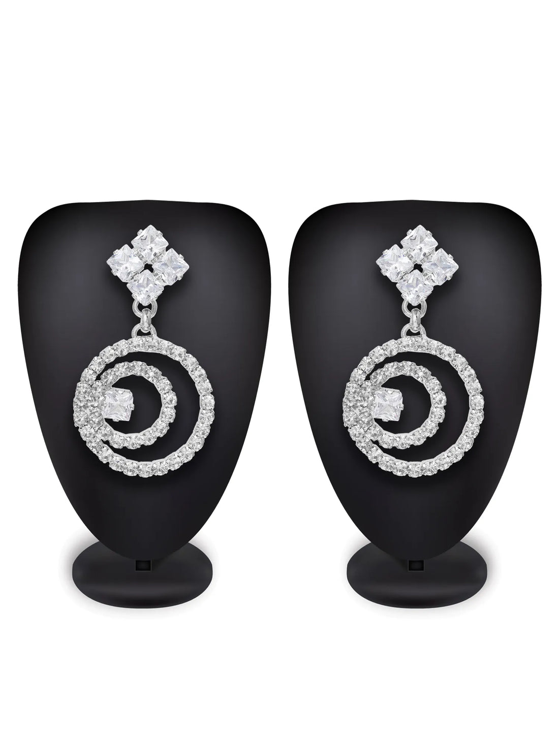 Silver spiral earrings on a green textured background