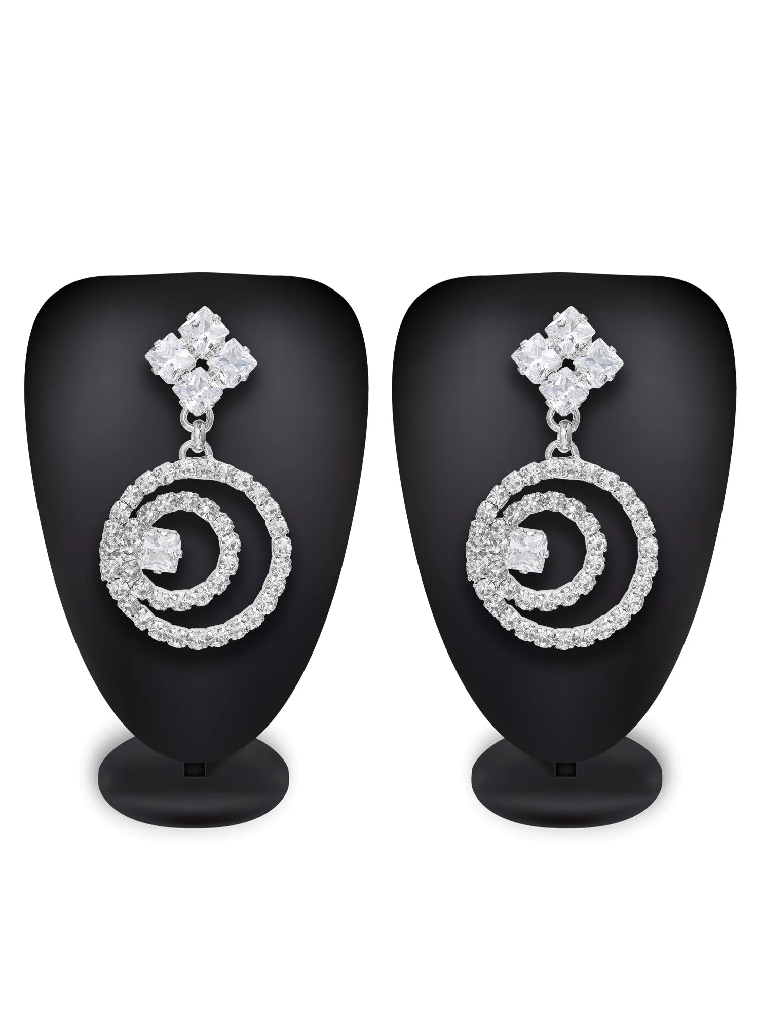 A pair of silver-toned drop earrings with a diamond-cut top and a double-ring spiral design, displayed on black mannequin busts against a white background.