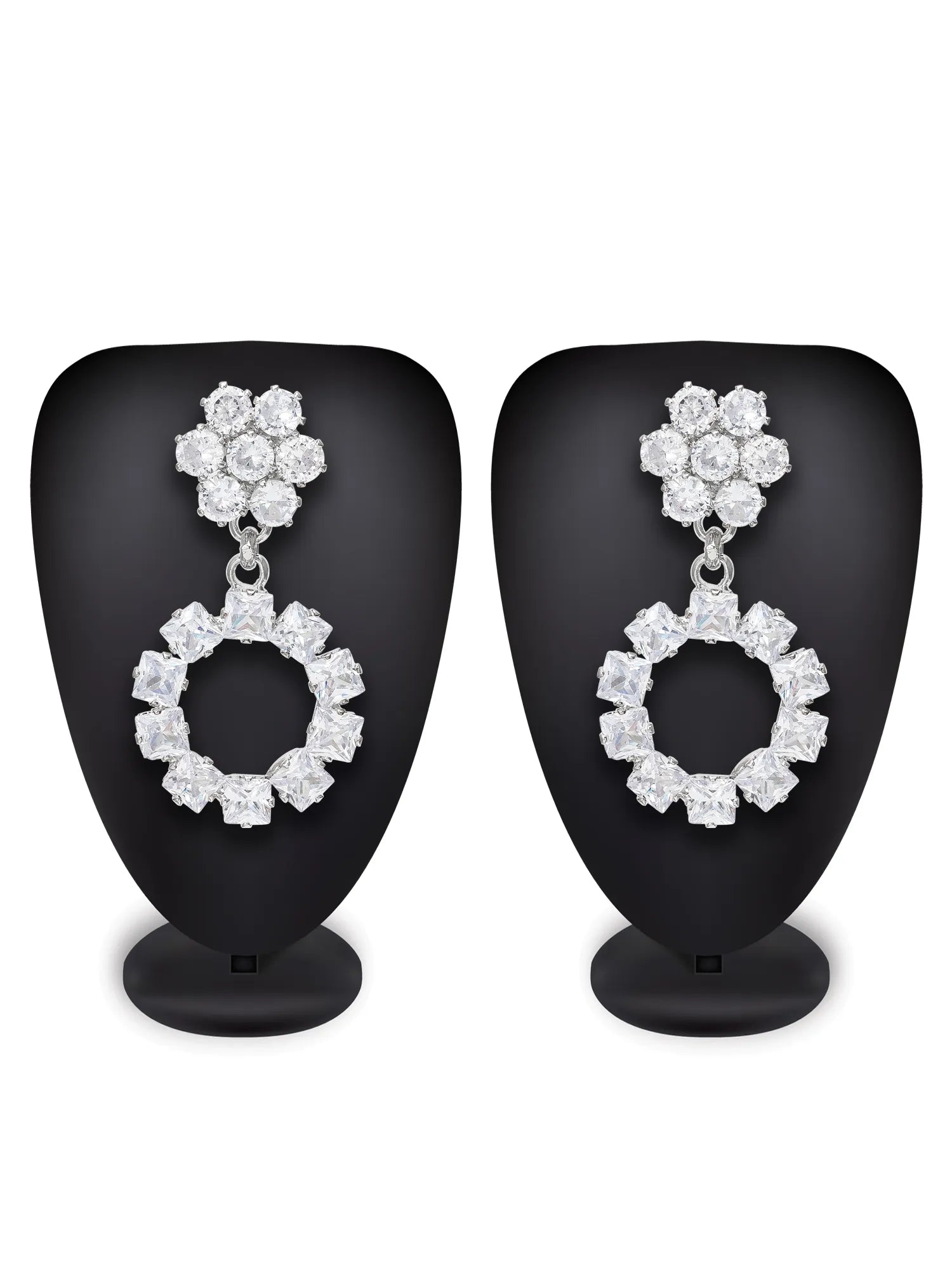 Pair of diamond earrings on black stands against a white background