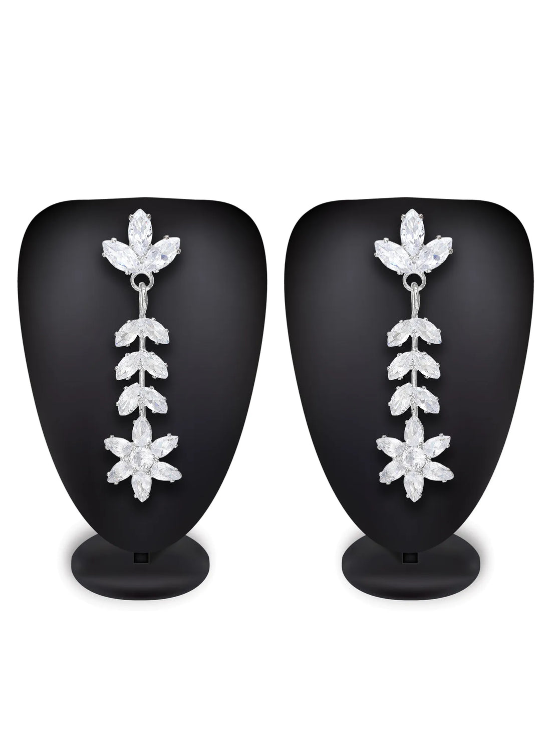 Silver floral earrings on a green background