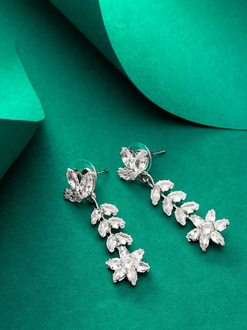 Silver floral earrings on a green background