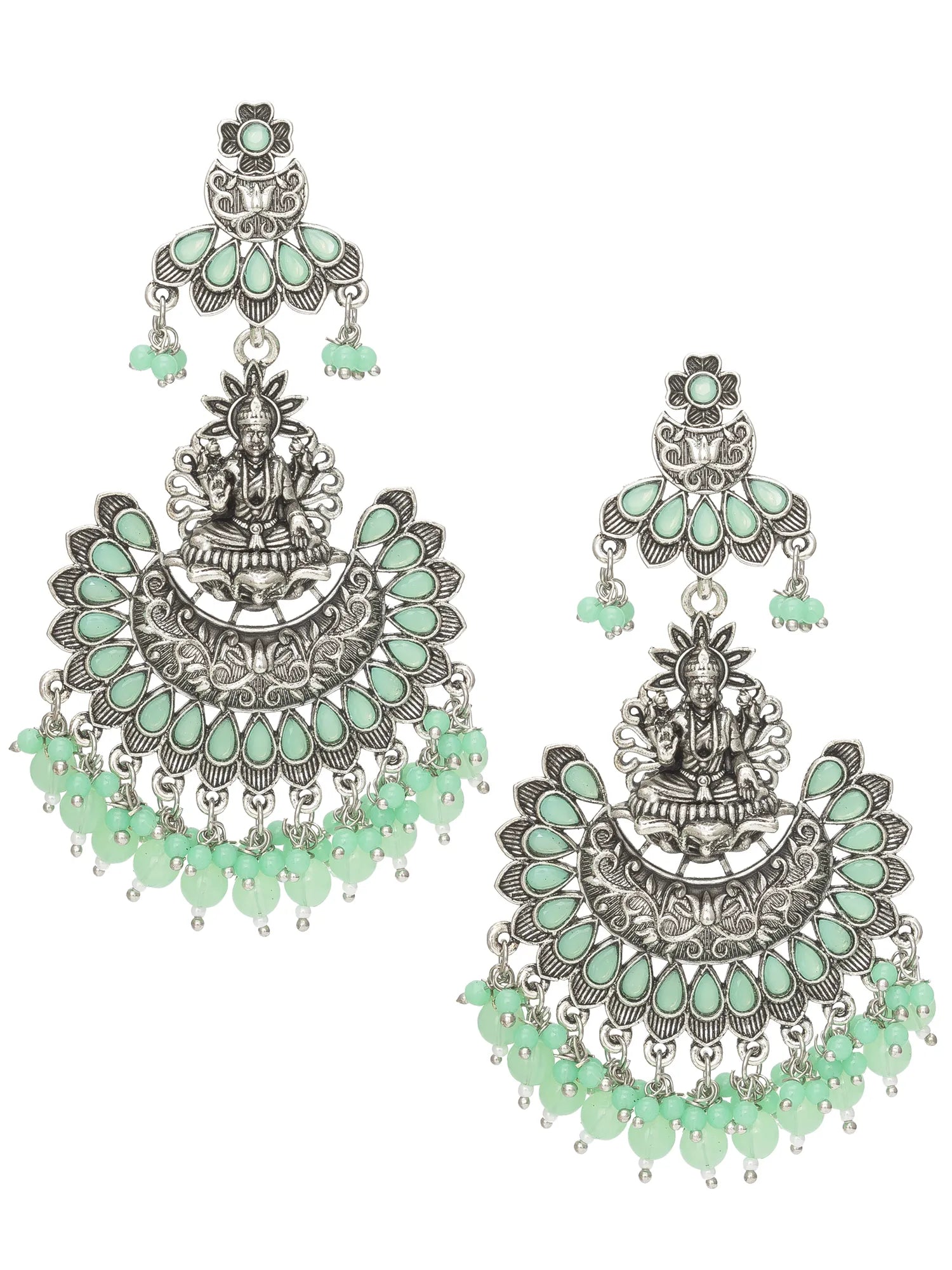 A pair of traditional Indian silver-toned chandelier earrings decorated with mint green teardrop stones and featuring a central deity motif, shown against a plain white background.