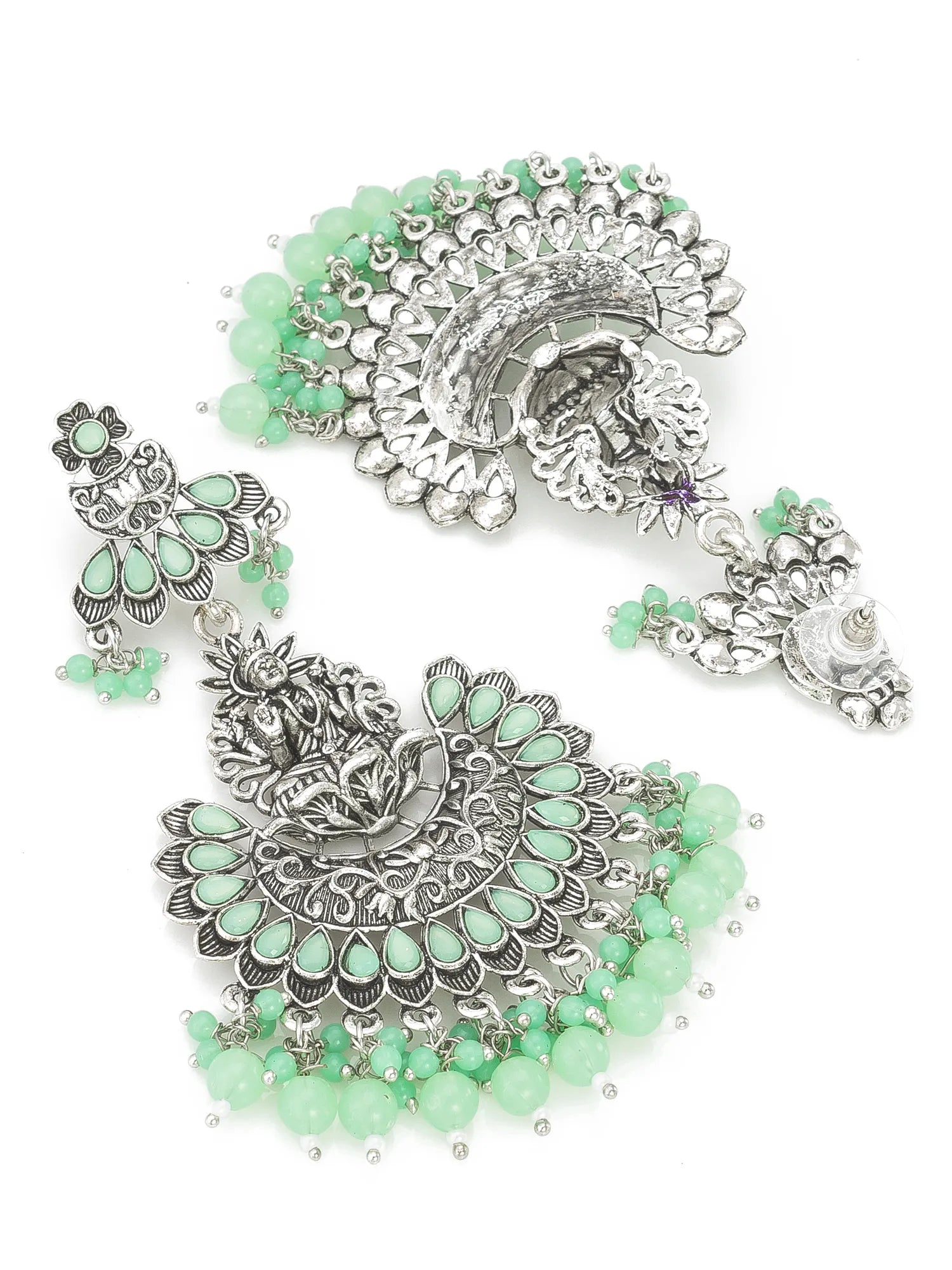 Ornate silver and green jewelry set on a white background