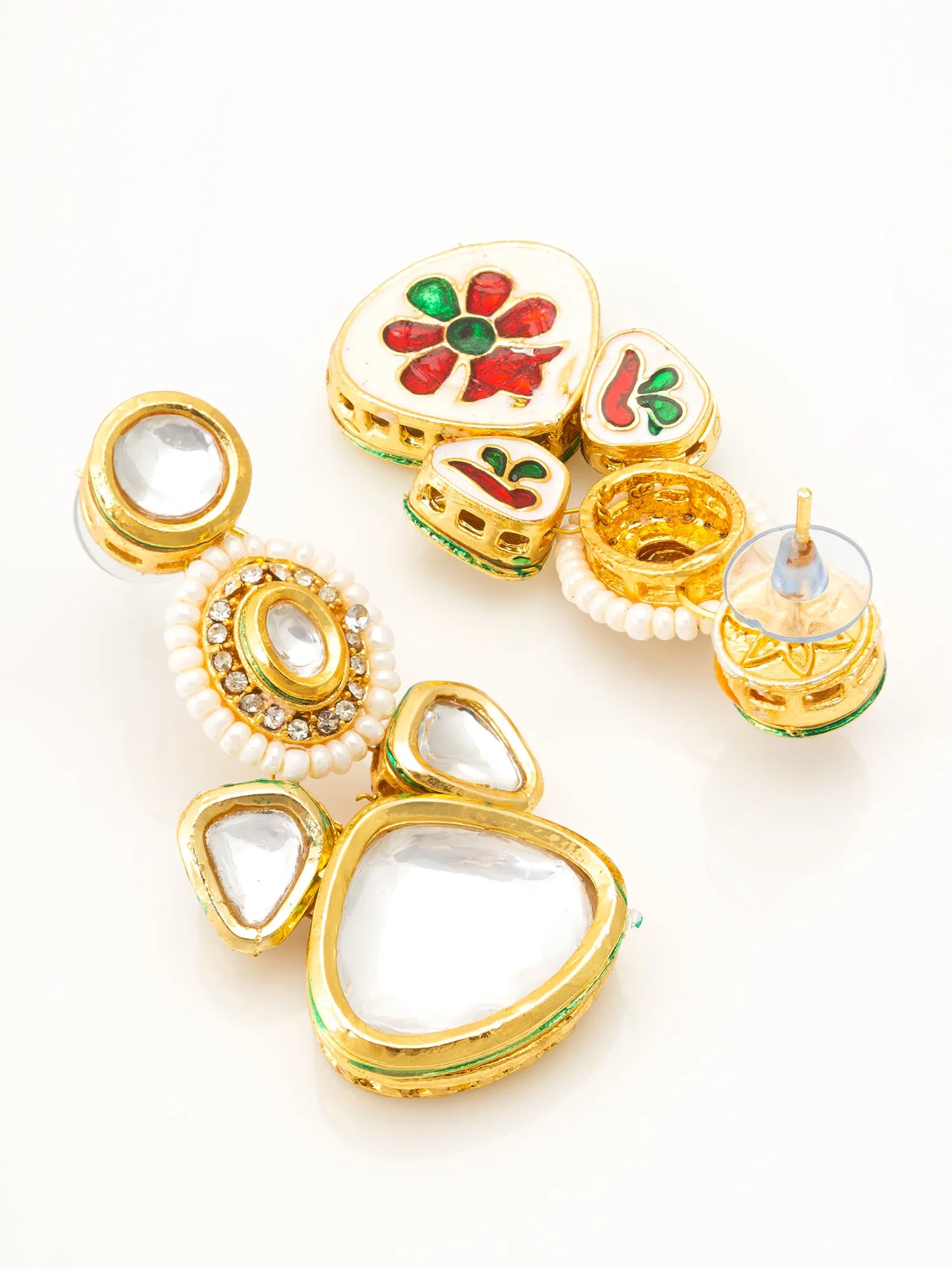 A set of gold-plated Indian Kundan earrings with clear stone borders, white pearl-like bead borders, and colorful red, green, and white enamel floral details, displayed on a clean white background.