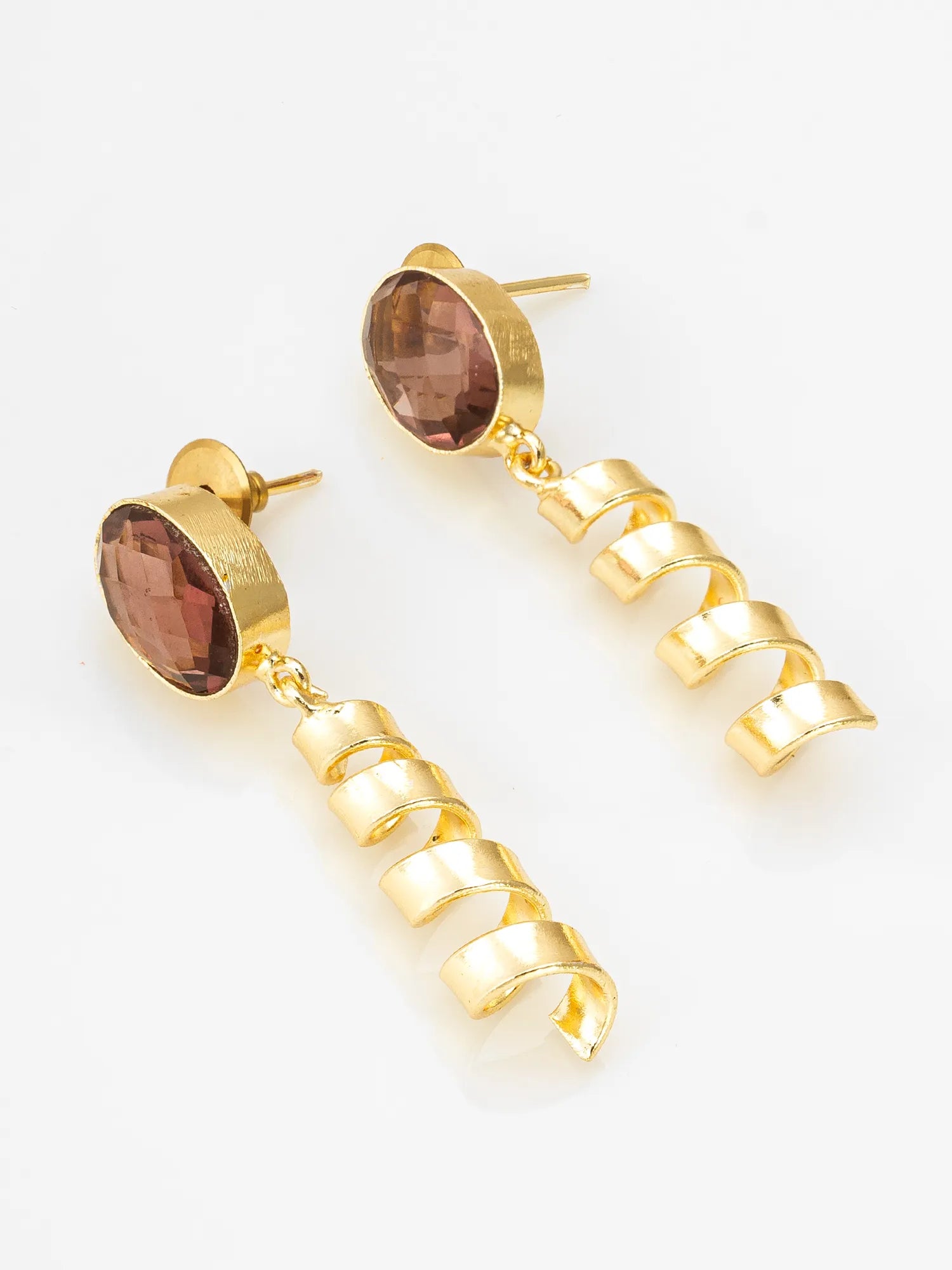 A pair of gold drop earrings featuring oval faceted brown gemstones at the top and a dangling spiral-shaped gold chain below, shown on a plain white background.