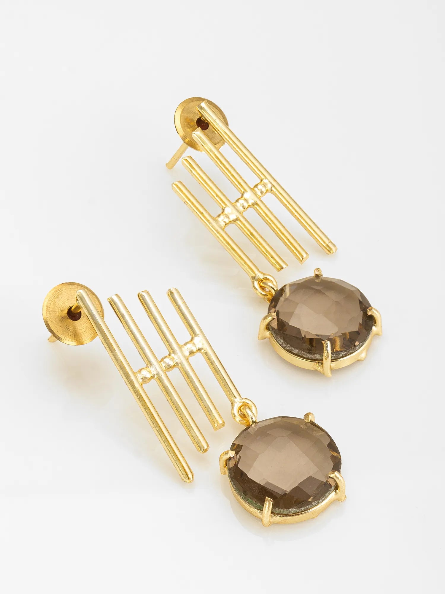 A pair of gold drop earrings featuring a multi-bar geometric dangle and a faceted oval smoky brown gemstone, shown on a clean white background.