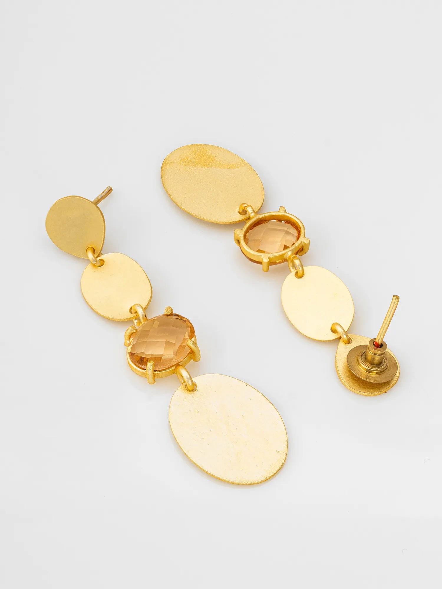 Gold earrings with multiple oval-shaped pendants on a light gray background