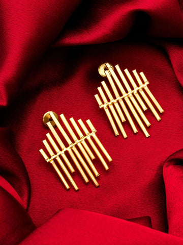Gold earrings on a red fabric background