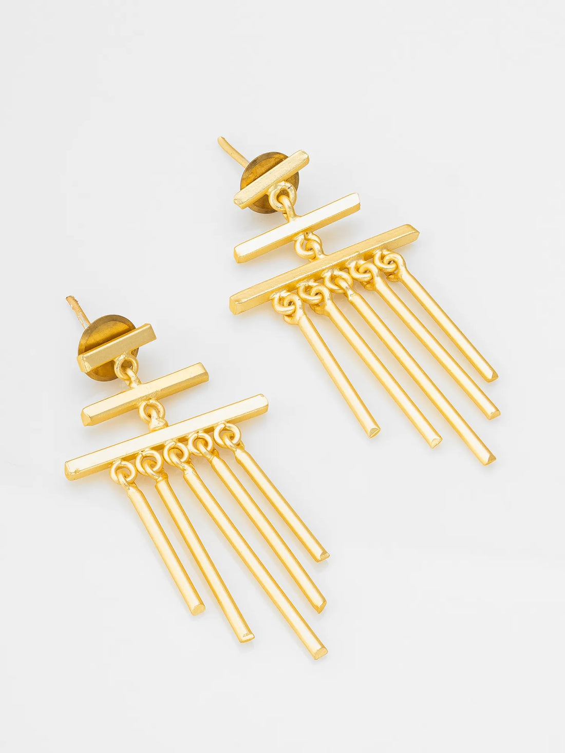 Gold earrings on a red fabric background
