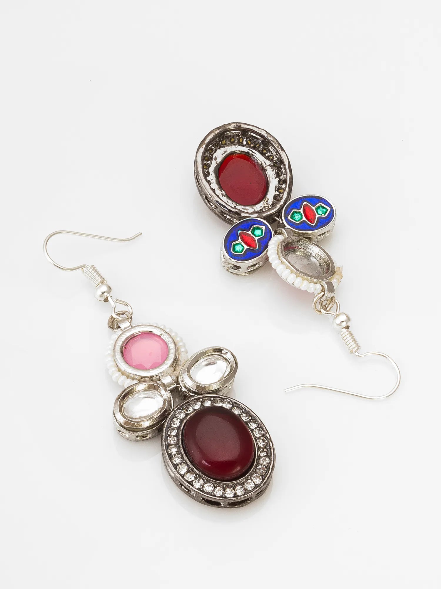 Pair of earrings with red and pink stones on a white background