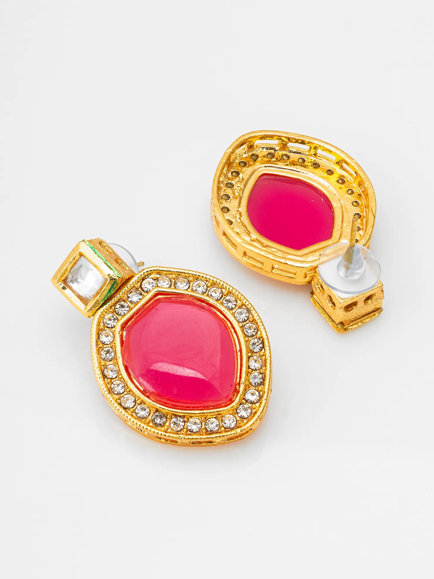 A pair of gold-plated statement earrings featuring large, vibrant hot pink teardrop-shaped stones surrounded by a border of small clear rhinestones, shown on a clean white background.