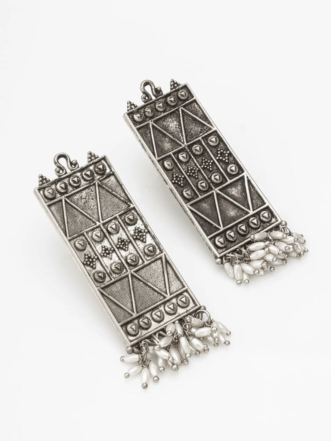 Decorative silver earrings on a red fabric background