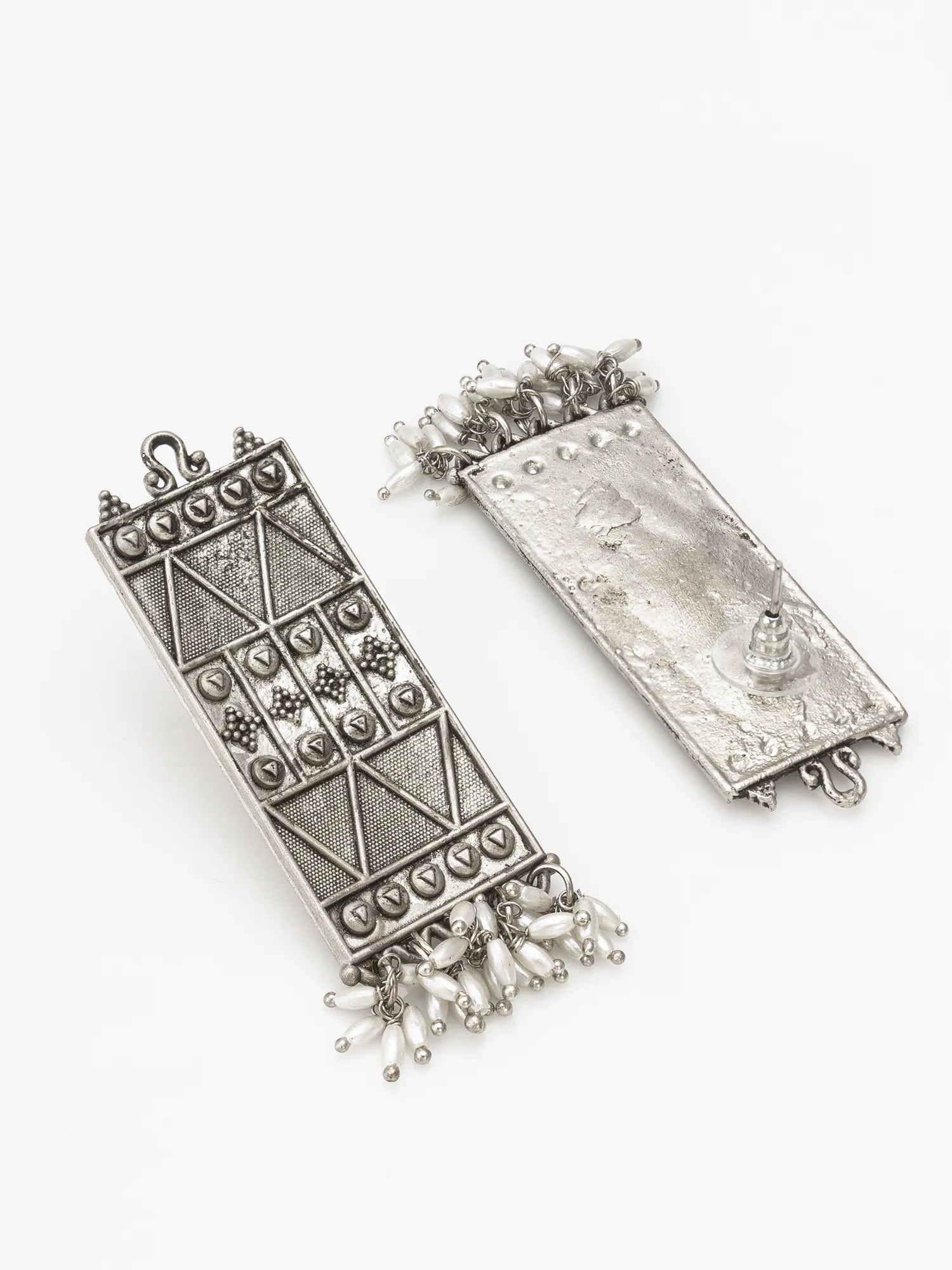Pair of silver earrings with intricate designs on a white background