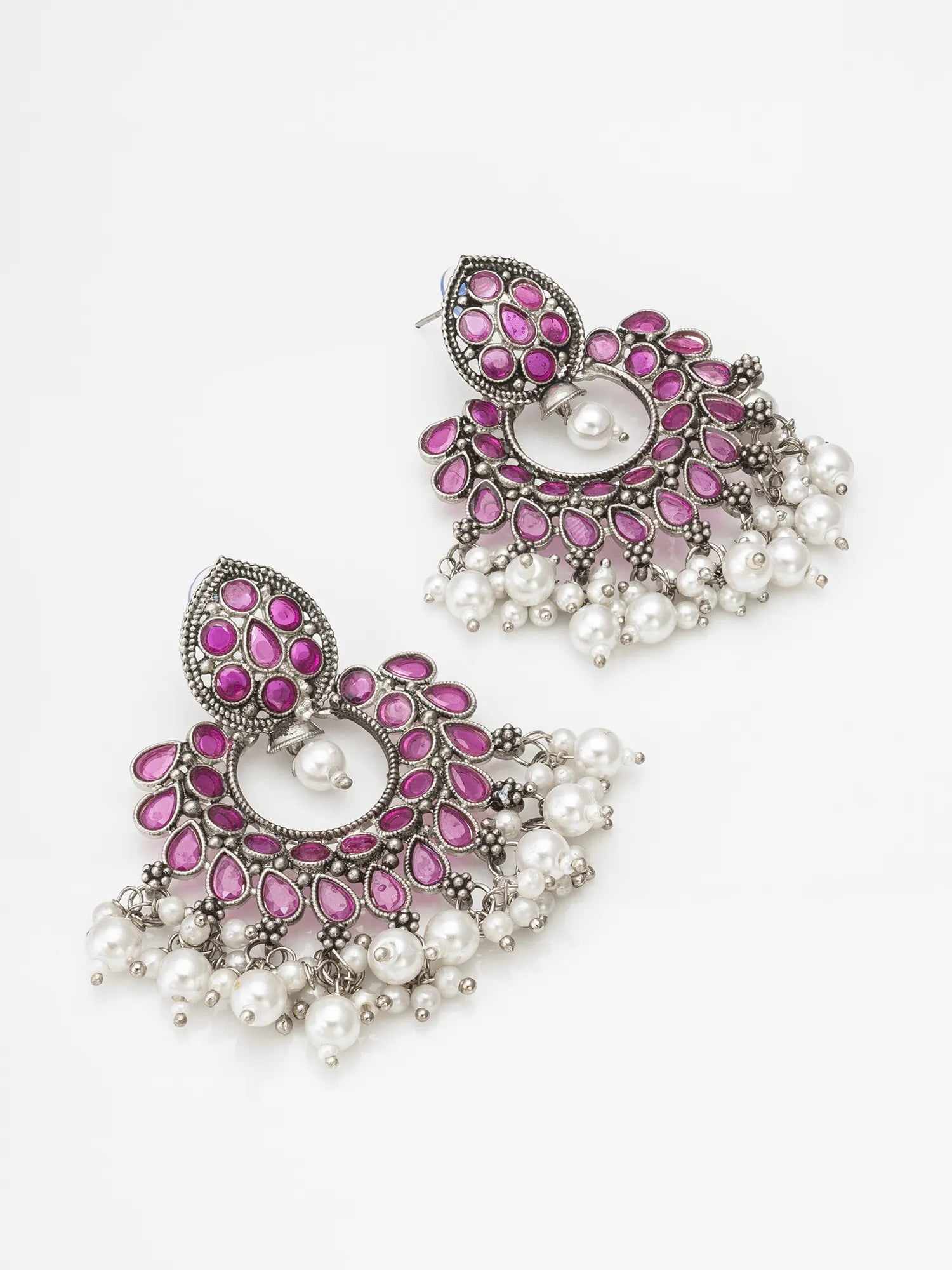 A pair of ornate silver-toned chandelier earrings decorated with pink stones and white pearl bead drops, shown on a clean white background.