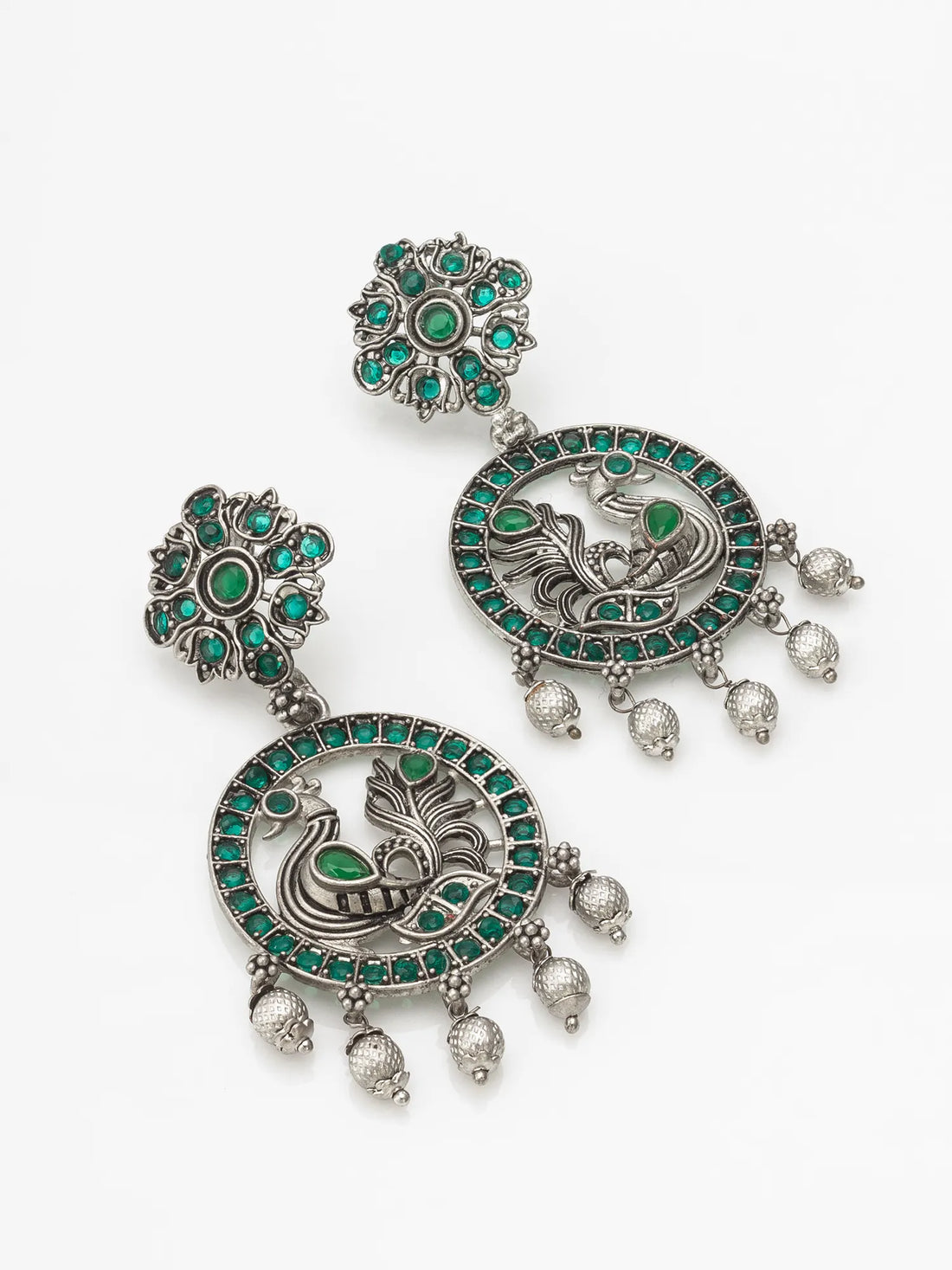Oxidized Peacock Chandbali Earrings On A Red Background