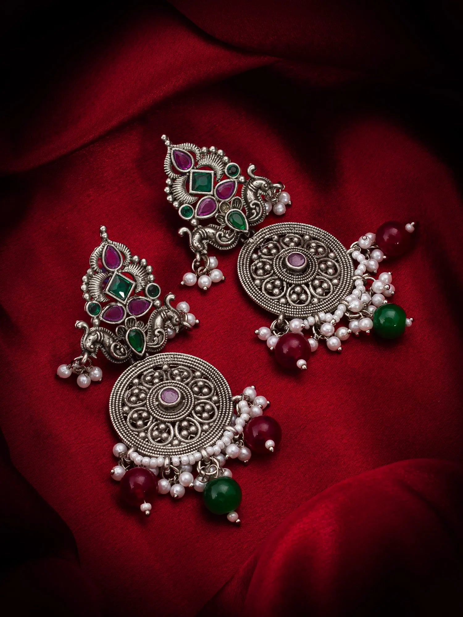 Peacock Oxidized Chandelier Earrings  On A Red Background
