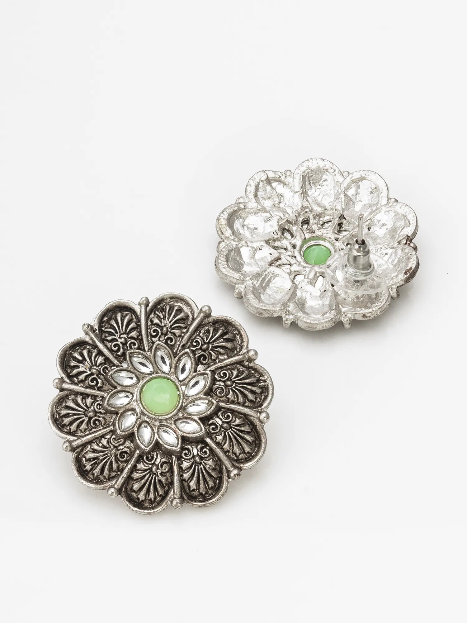 Two silver-toned flower-shaped brooches with green oval center stones, displayed on a clean white background.