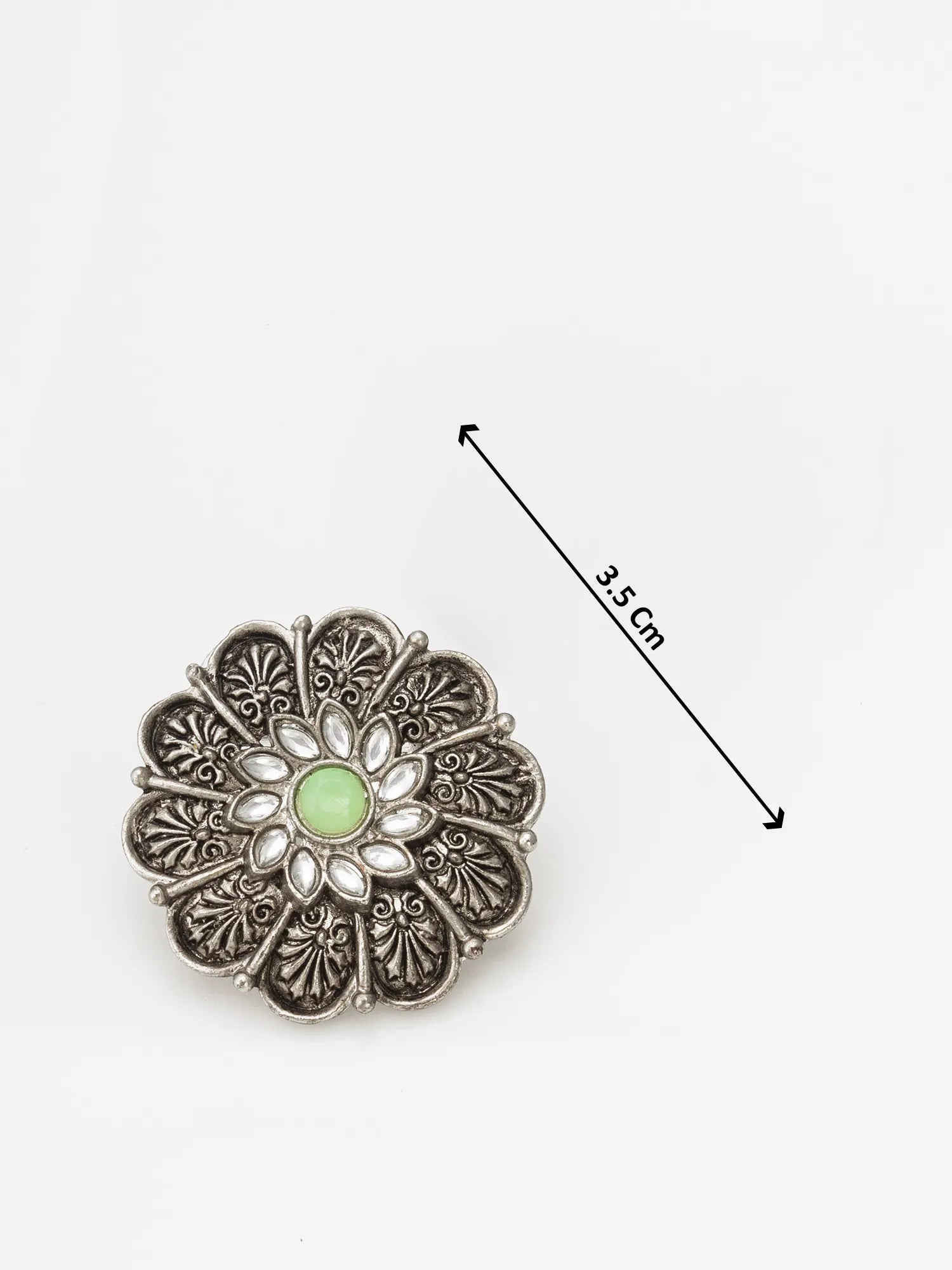 Decorative brooch with a green gemstone and silver filigree design, shown with a measurement label on a white background.
