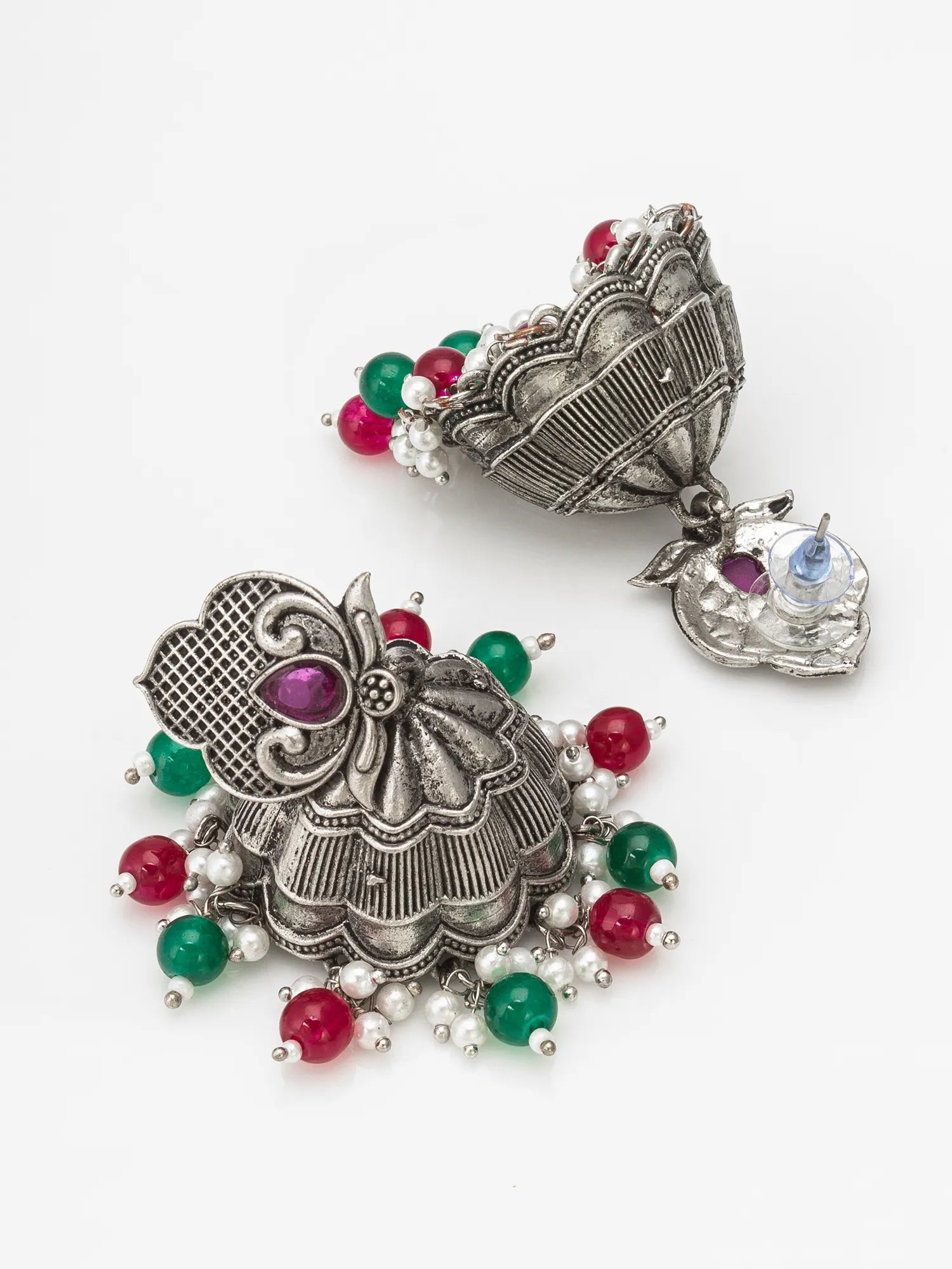 A pair of ornate silver-toned traditional Indian jhumka earrings decorated with red, green, and white beads, displayed on a clean white background.