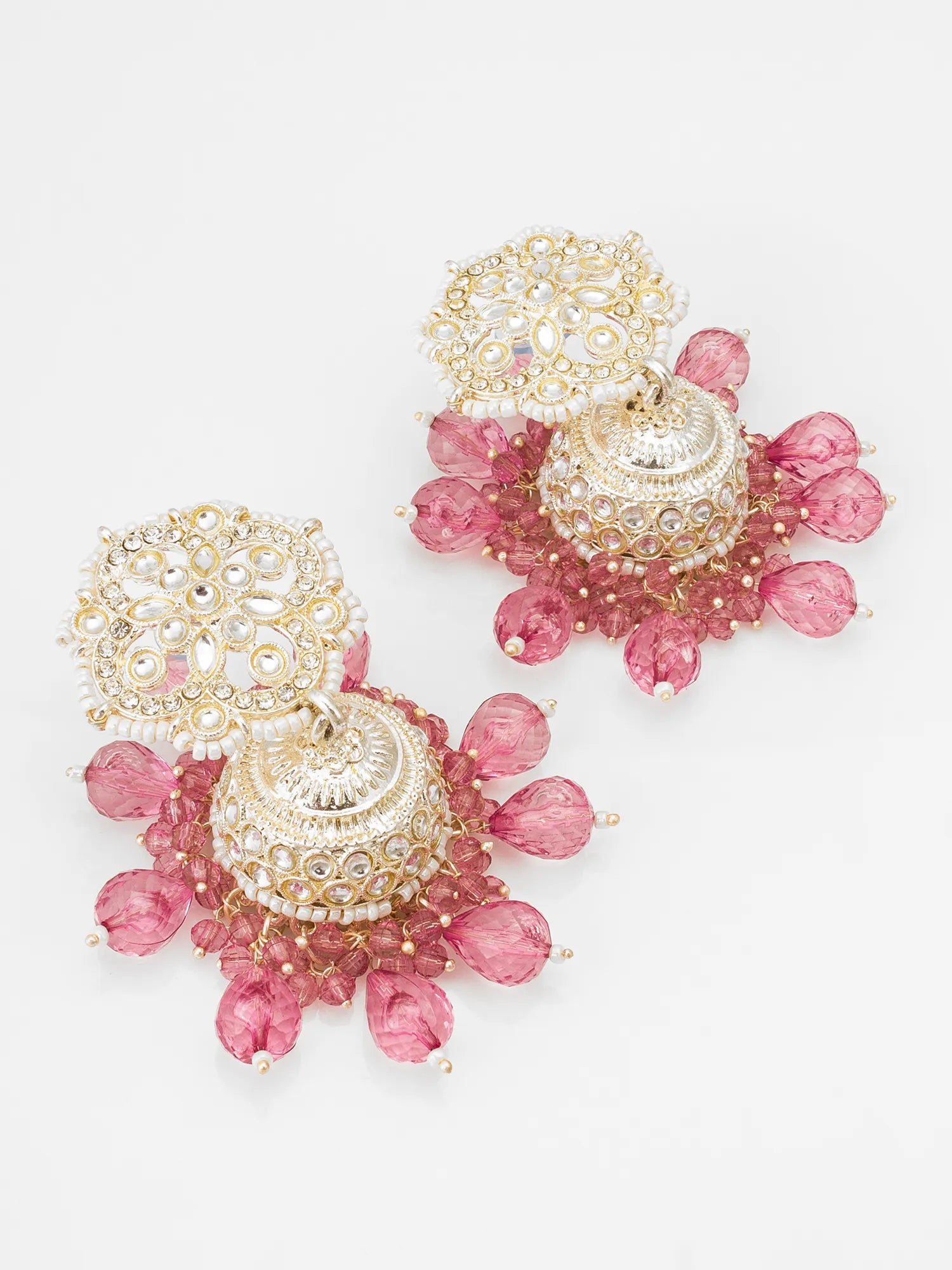 Gold and pink earrings on a light gray background