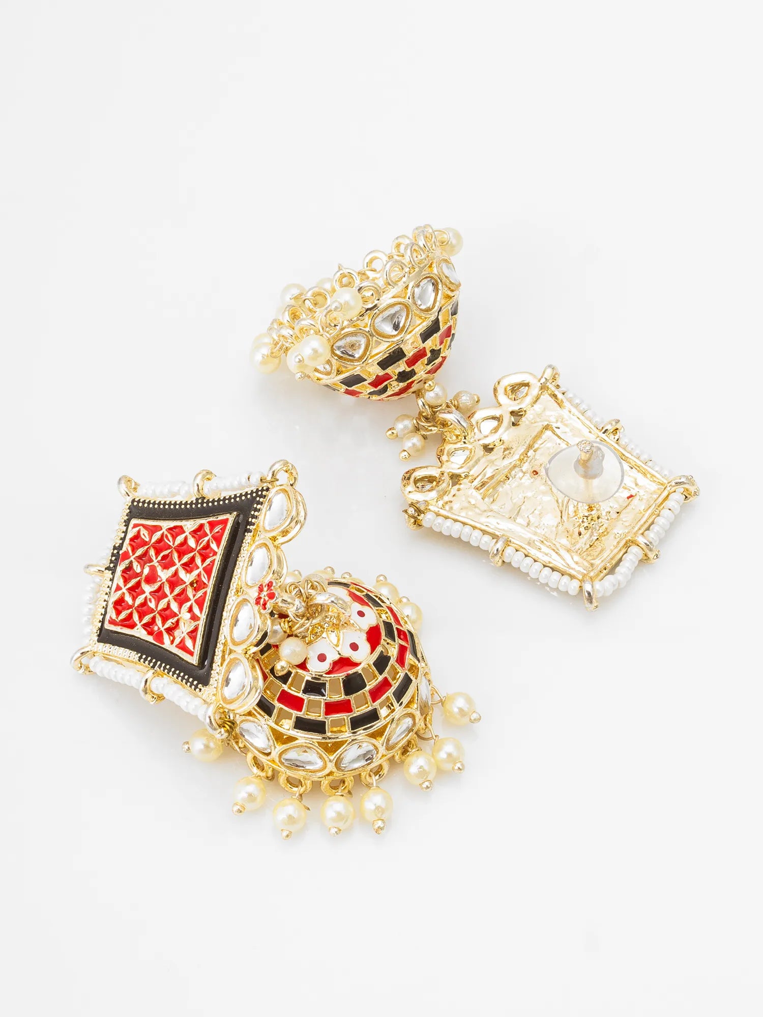 A set of three ornate gold-toned traditional Indian earrings with red, black, and white enamel details and clear stone accents, displayed on a clean white background.