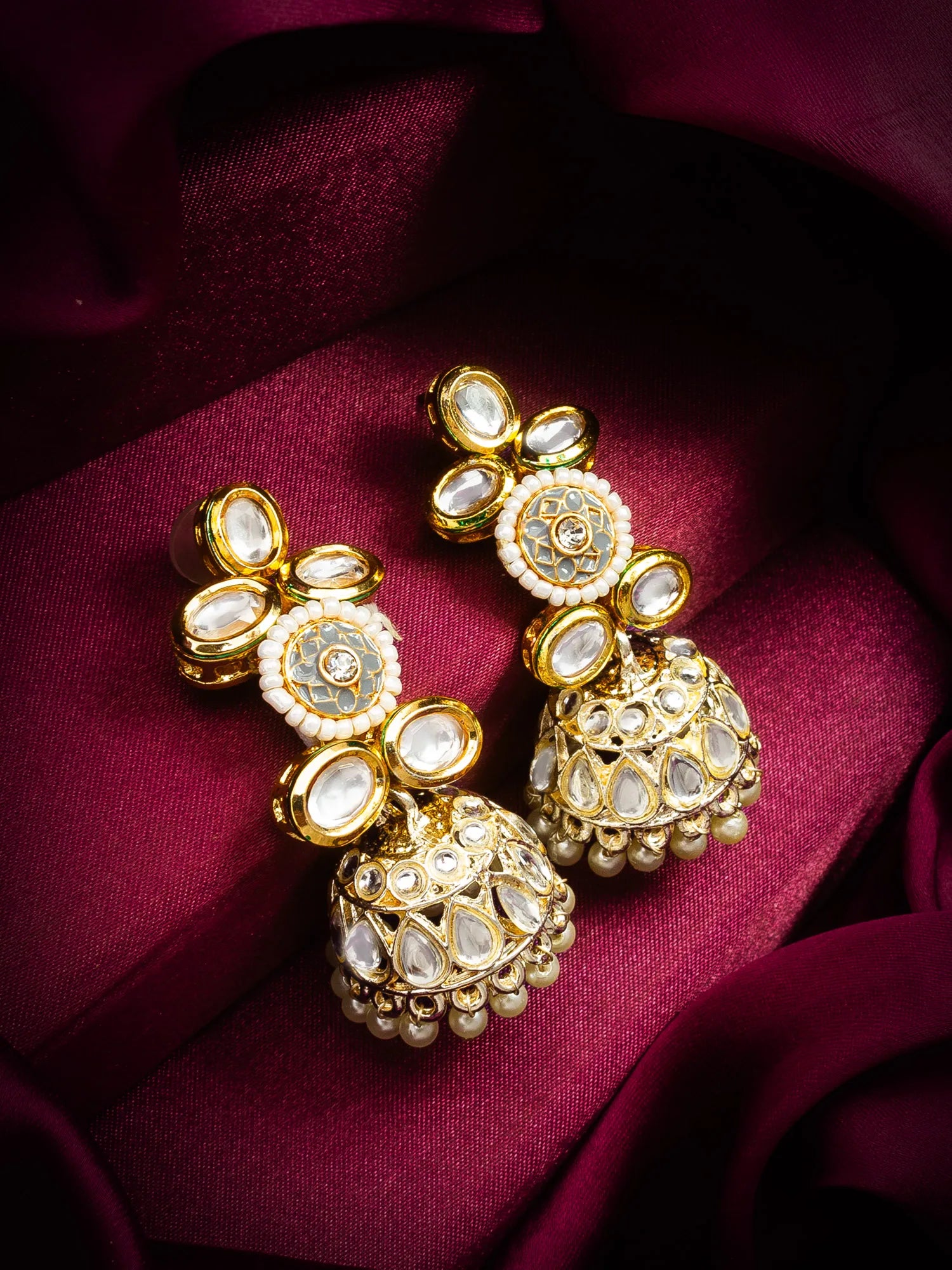 Kundan Jhumka Earrings On A Red Background