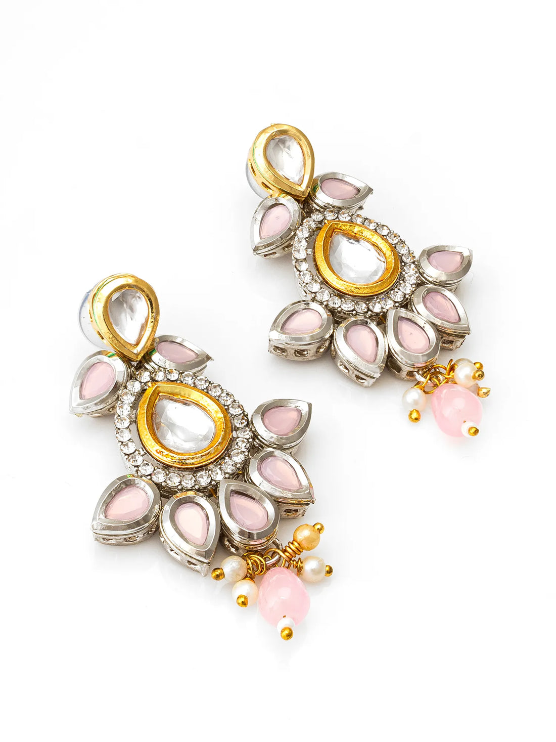 Ornate earrings with pink stones on a maroon fabric background