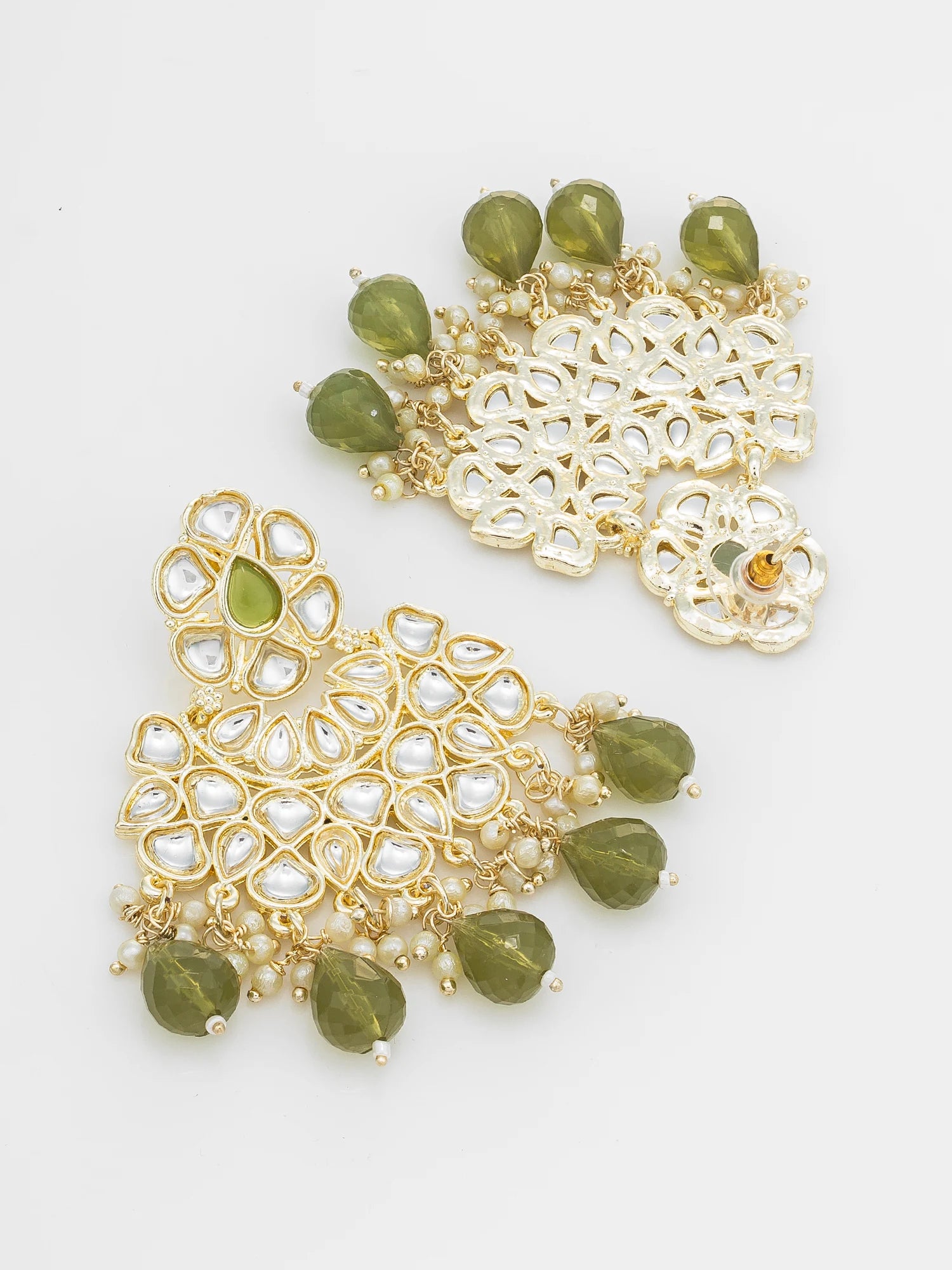A pair of gold-plated Indian jhumka earrings decorated with white faux pearls and green faceted beads, displayed on a clean white background.