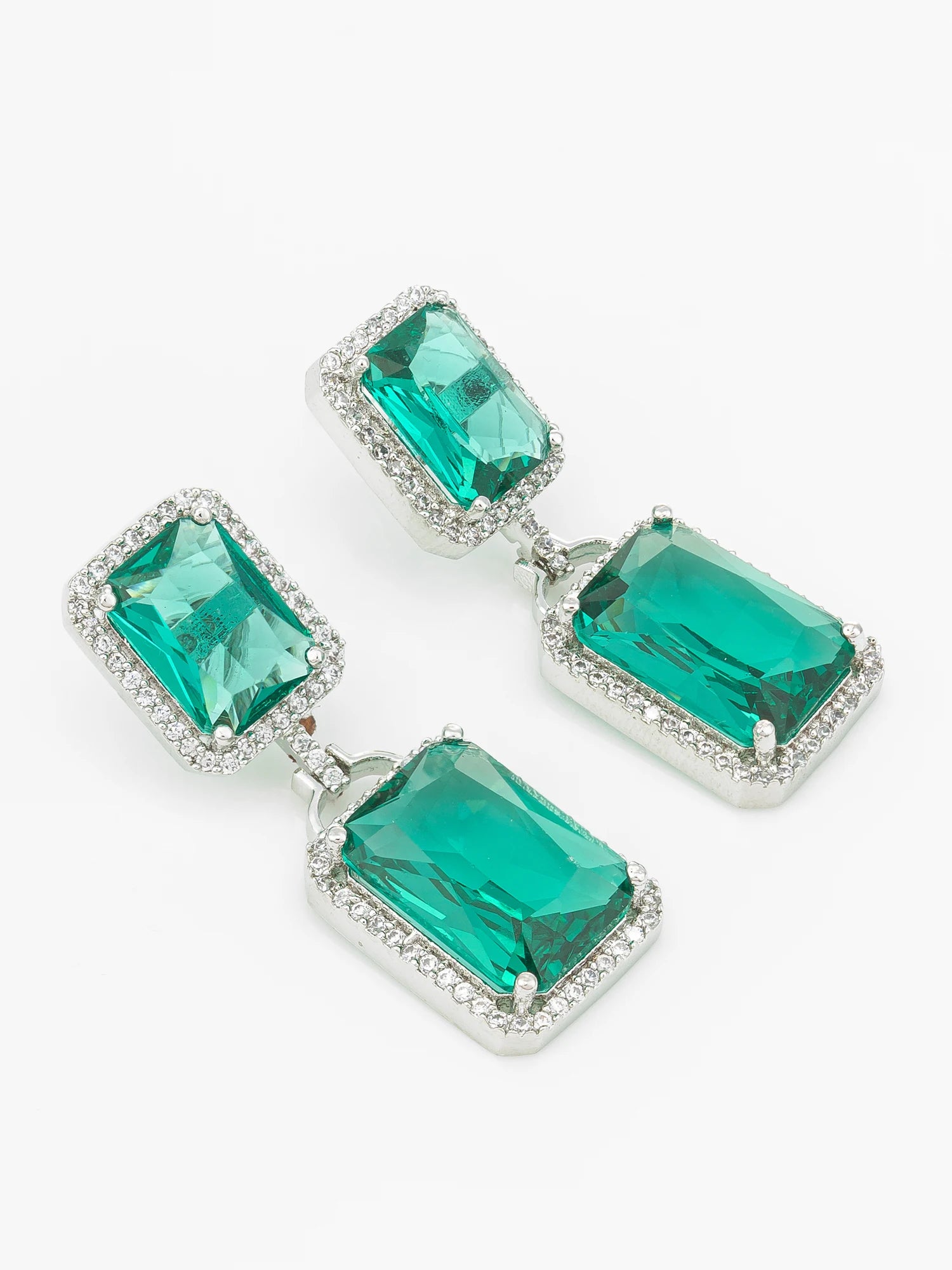 A pair of drop earrings featuring large rectangular emerald-cut green crystals in silver-toned settings with small clear accent stones, shown on a plain white background.