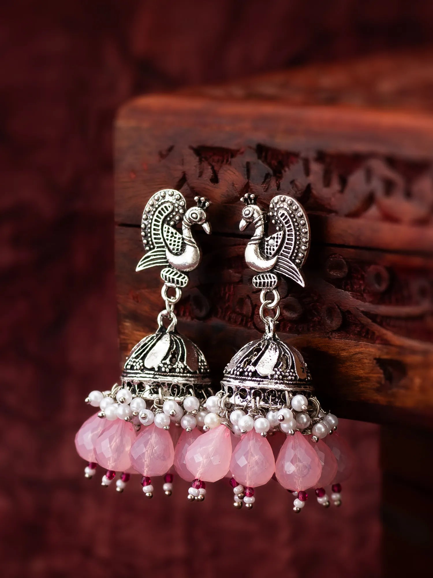  Oxidized Peacock Jhumka Earrings On A Background