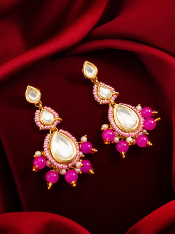 Pink Kundan Beaded Drop Earrings On A Red Background