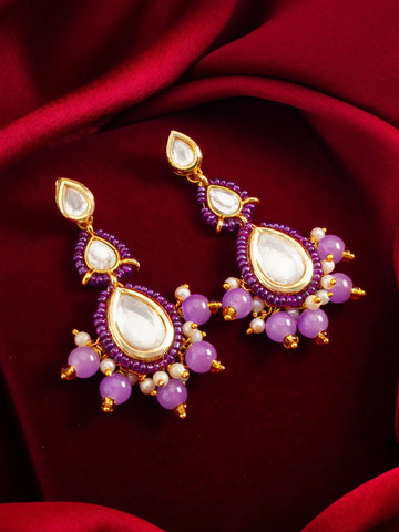Purple Kundan Beaded Drop Earrings On A Red Background