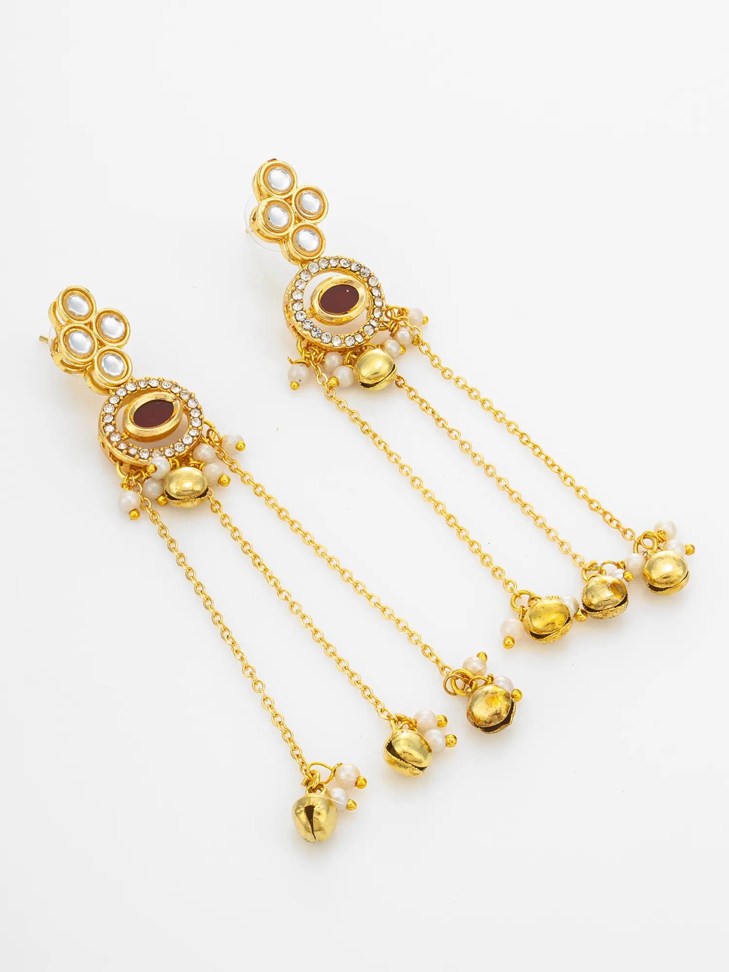 A pair of gold-toned traditional Indian earrings with white pearl-like beads, small clear stones, and dangling chain ends with gold bells, shown on a plain white background.